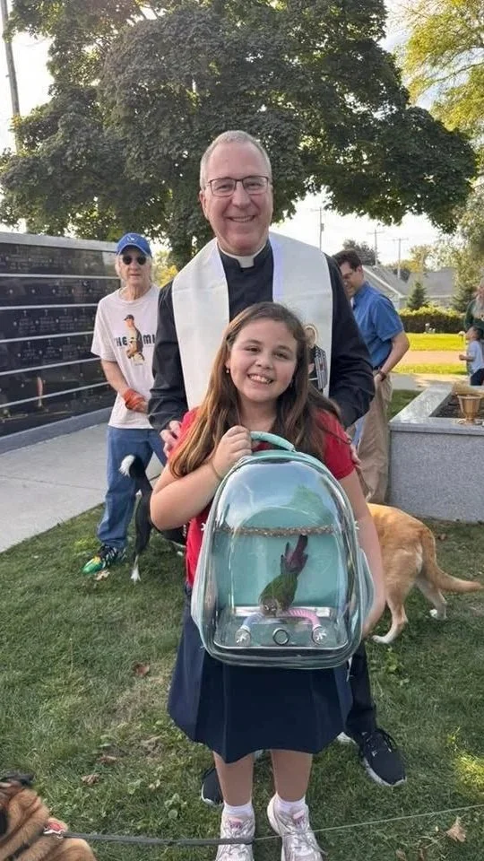 Fr. Jerry Herda blesses school children and parishioner pets on the Feast day of St. Francis of Assisi