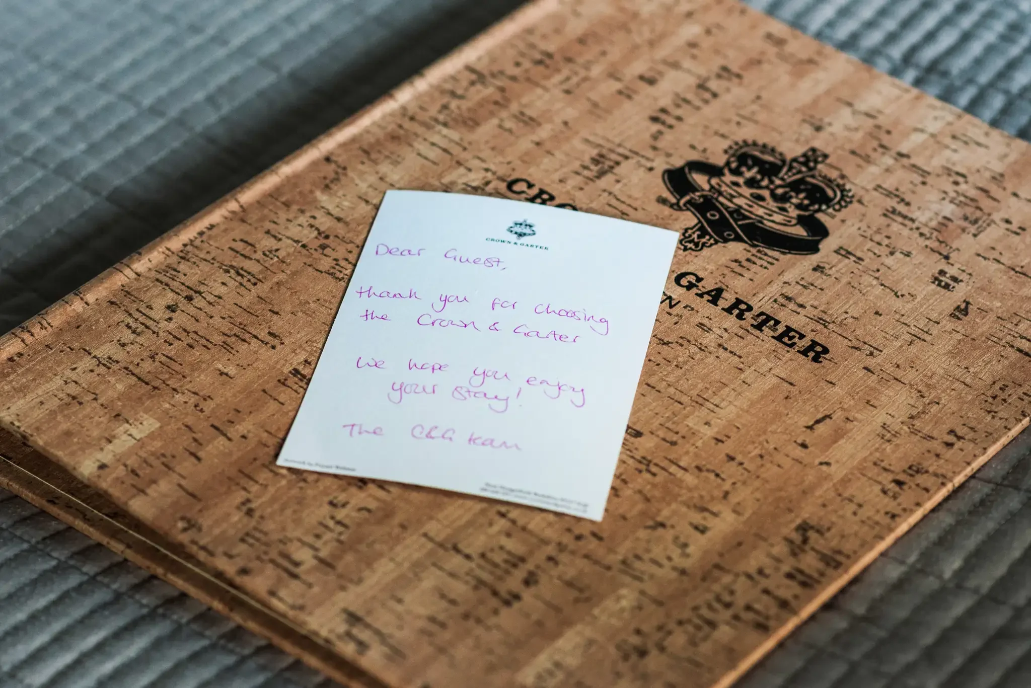 A wooden menu cover with a note on top, which reads: "Dear Guest, Thank you for choosing the Crown & Garter. We hope you enjoy your stay! The BBQ team."