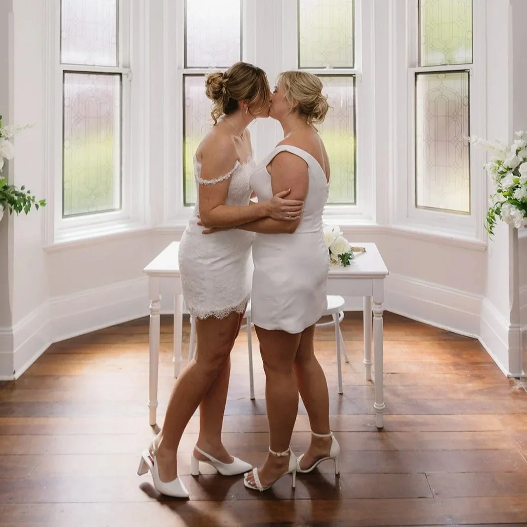 wedding dresses sharing a kiss 