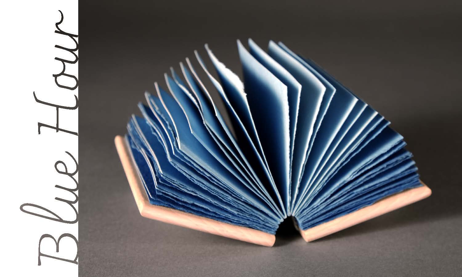 Open blue book with pages fanned out against a dark background with the title 'Blue Tales' on a white vertical banner.