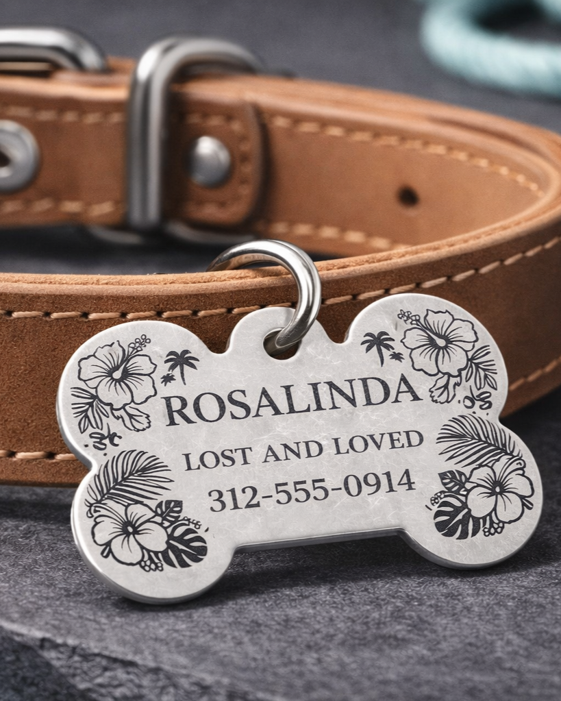 Dog collar with a metal pet tag engraved with the name Rosalinda, marked as lost and loved, with a phone number, on a black surface.