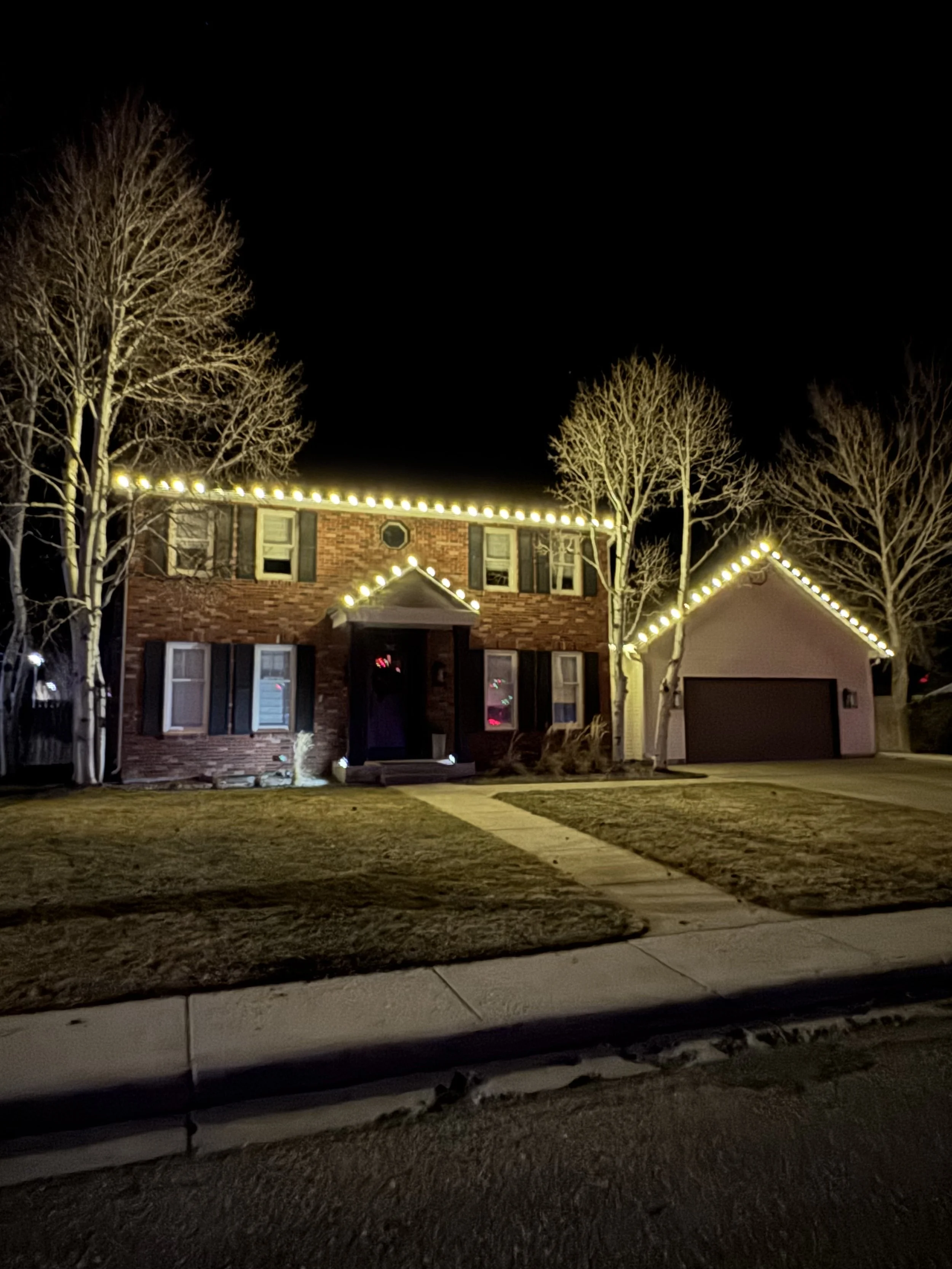 Christmas light installation outlining roof and windows, Cheyenne, WY home