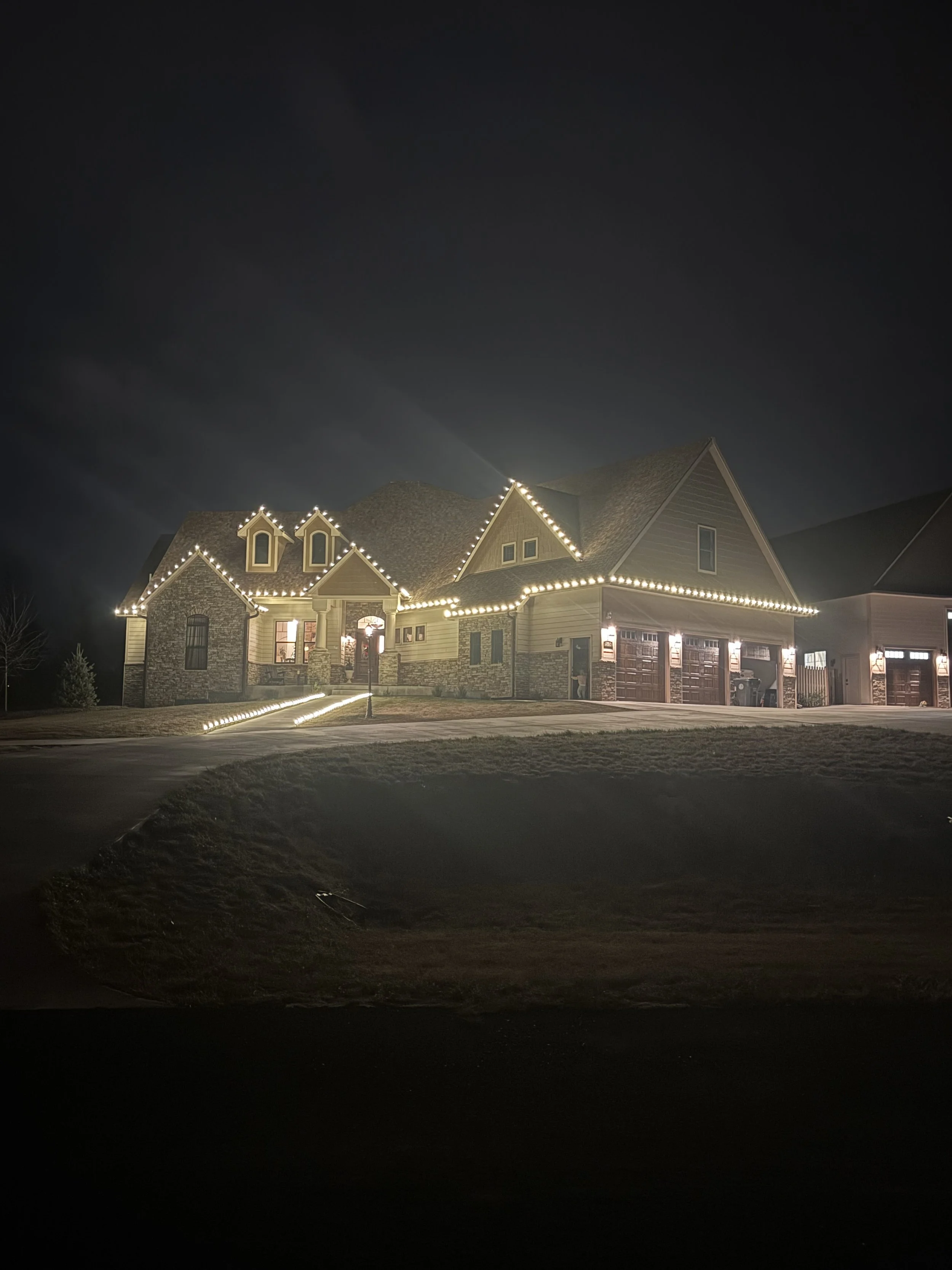 Multicolor holiday light display on snow-covered Cheyenne, WY yard