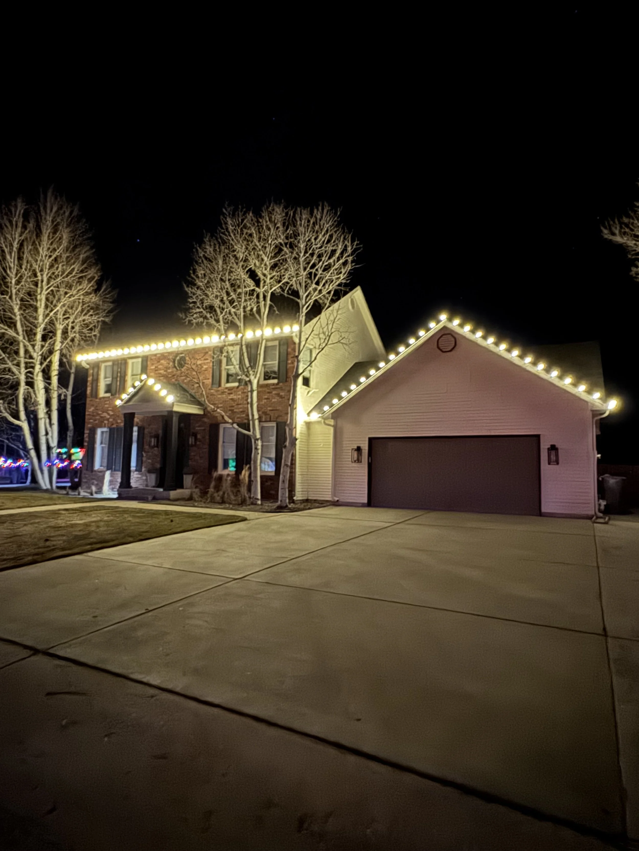 Two-story home with roofline Christmas light installation in Cheyenne, WY