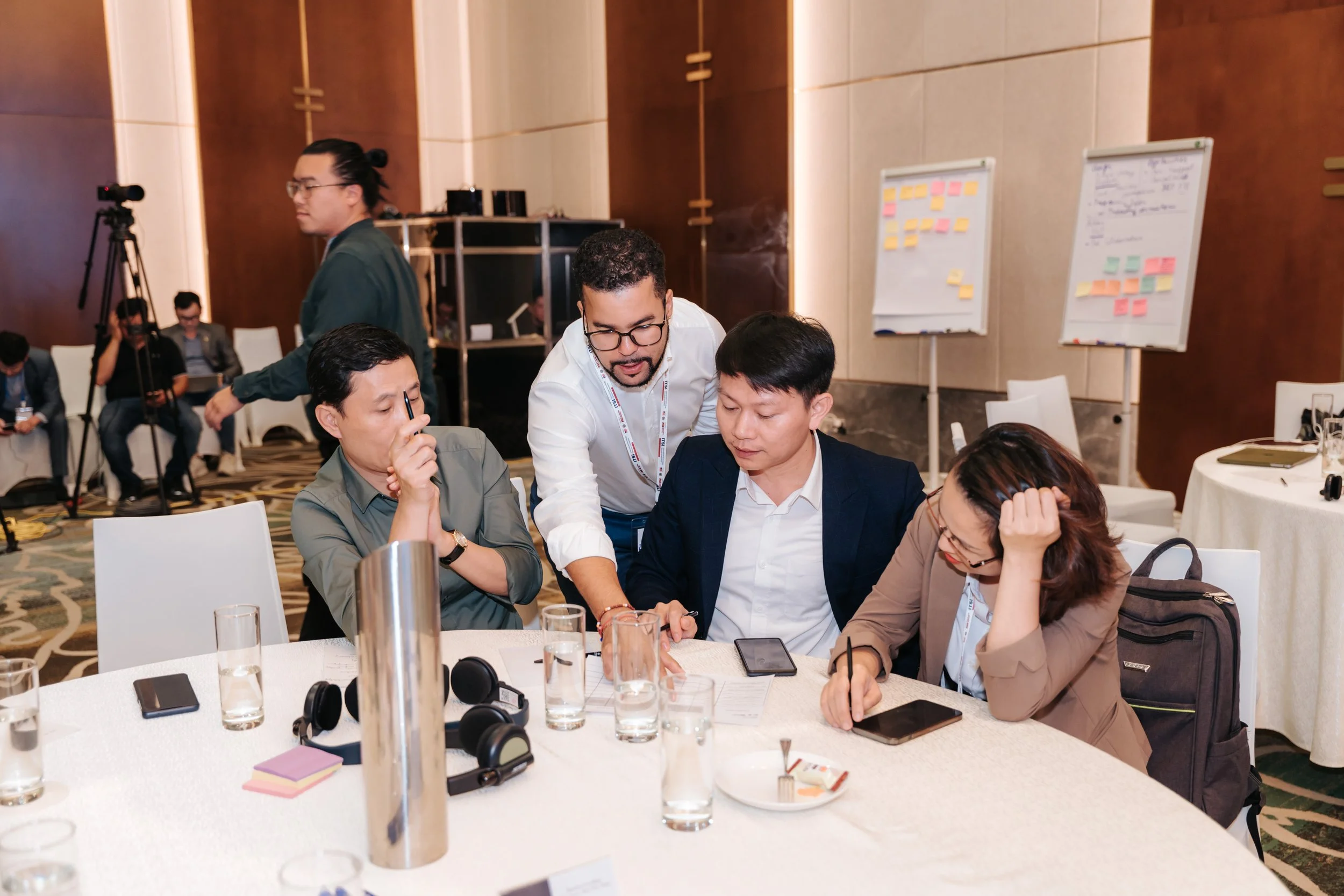 Romano Theunissen facilitating a group of diverse professionals collaborating on semiconductor strategy at a round table in a conference room in Vientam.