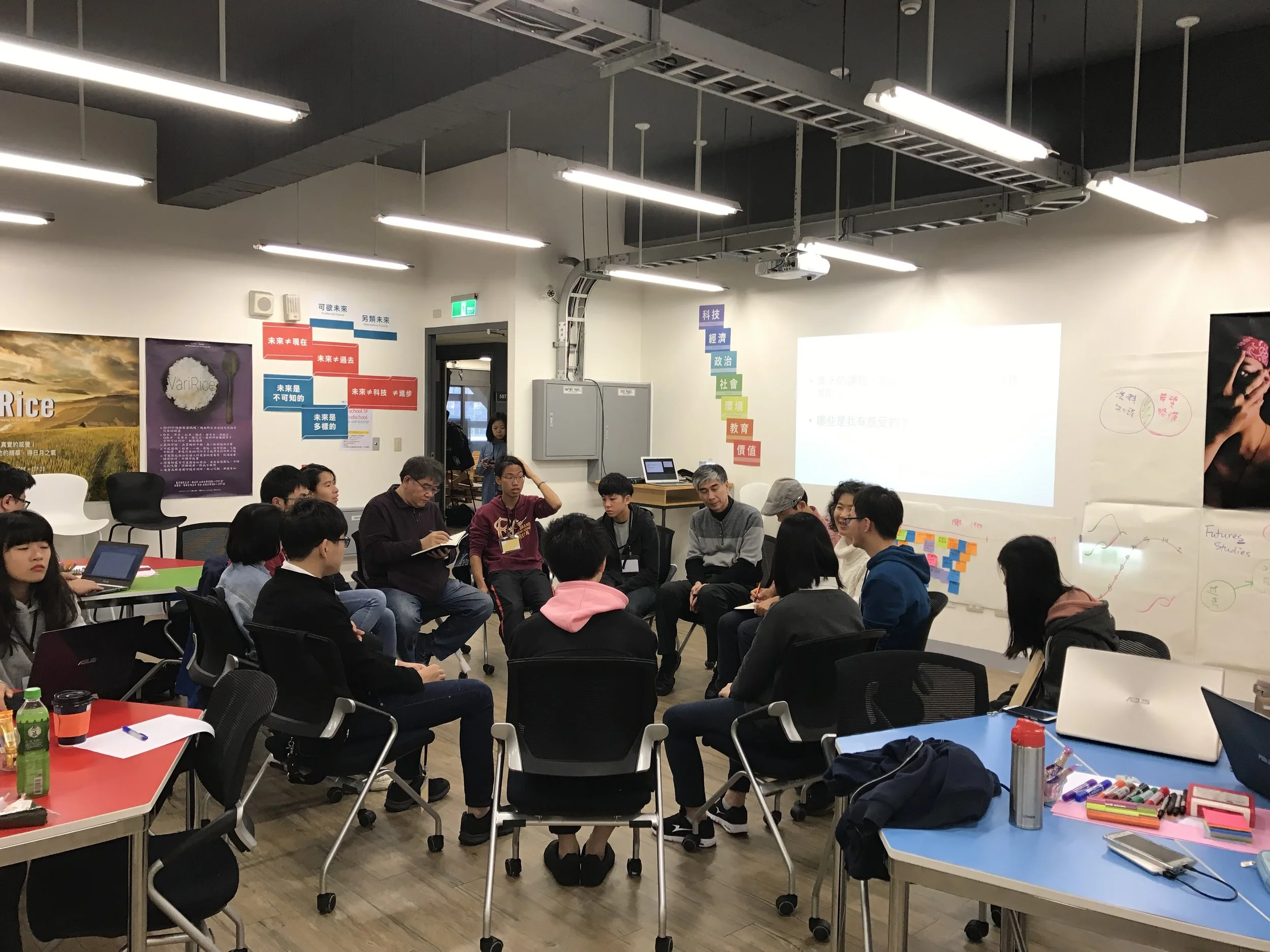 A group of people sitting in a circle in a conference room, participating in a discussion or workshop.