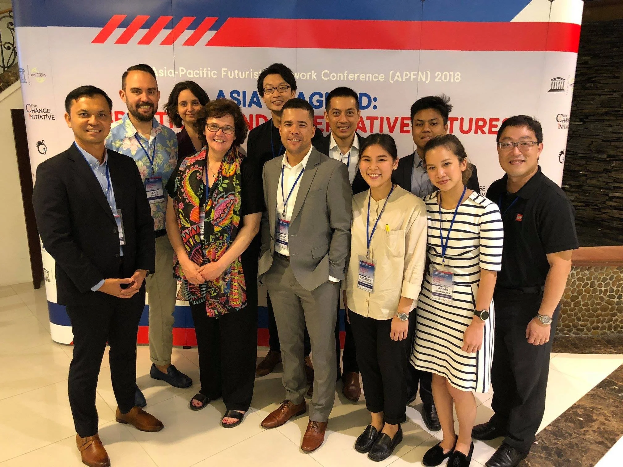 Group of people attending the Asia-Pacific Future Networks Conference 2018, standing in front of a conference banner.