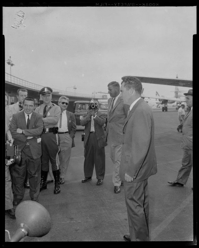 Vice President Richard Nixon at Logan Airport with police officer and photographers, June 1958. Photo by Gene Dixon.