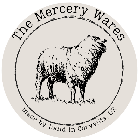 black and white circle emblem of a sheep for a handmade clothing business