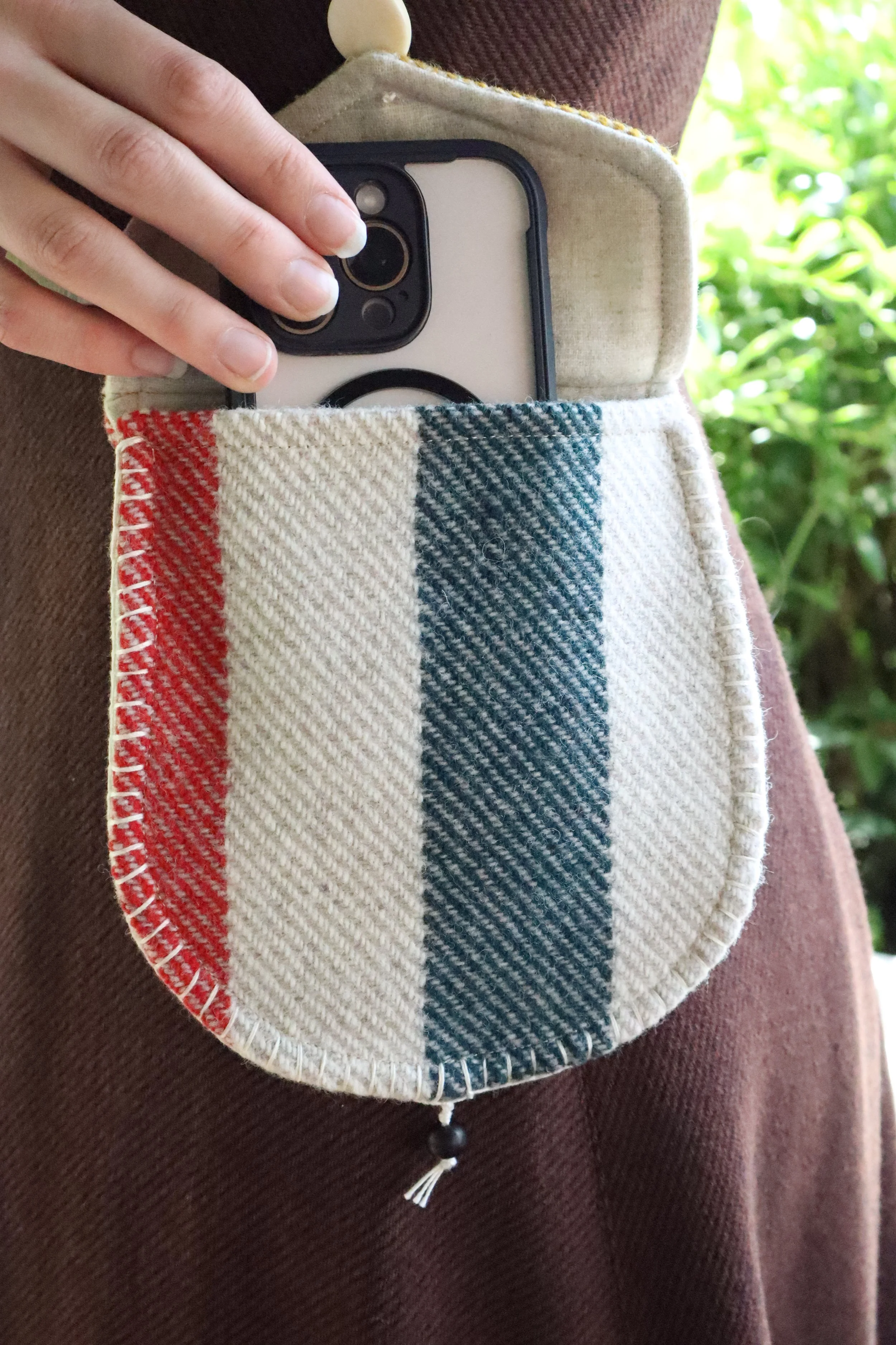 Tan and multicolor Wool Bag with cell phone being taken out of bag