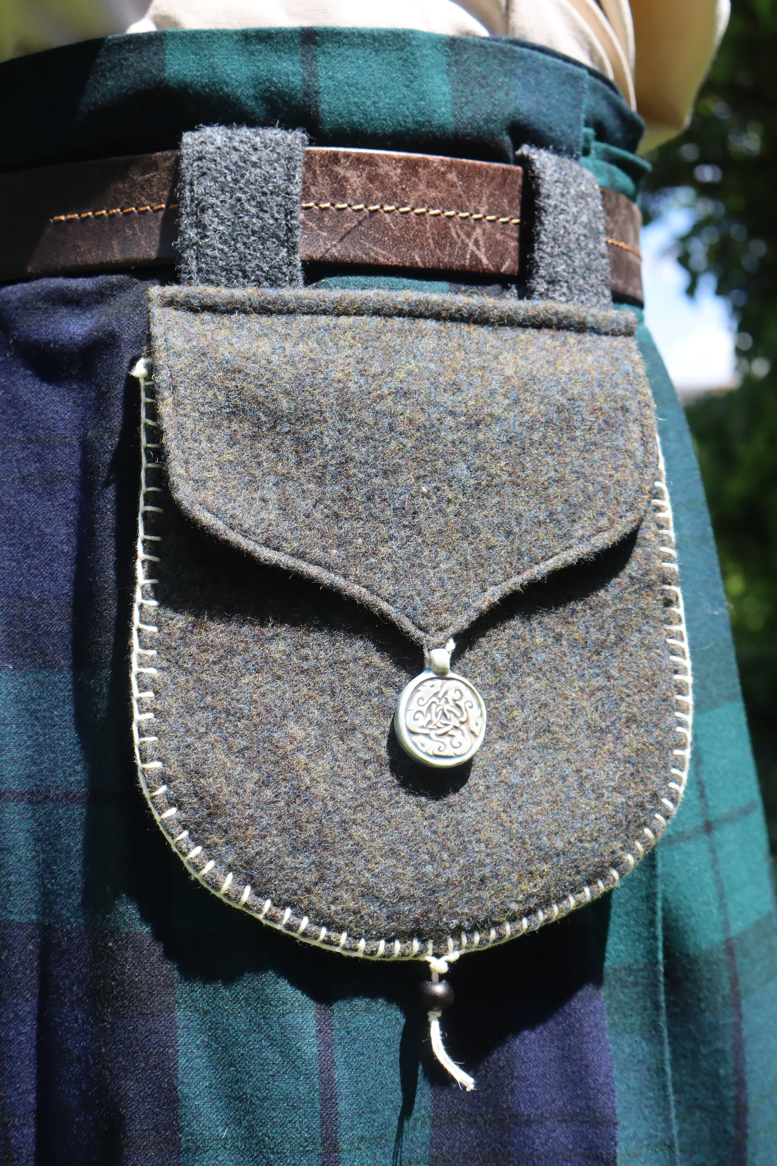 Grey Wool Bag with round clay clasp with plaid in the background