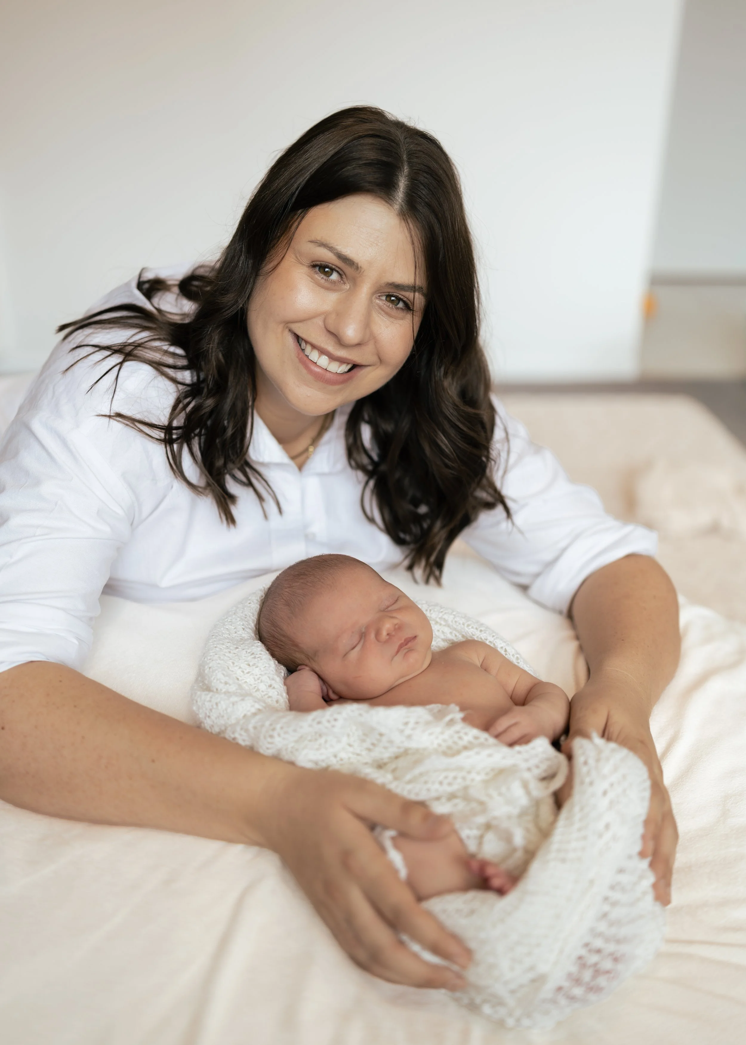 mother cuddling newborn baby sleeping at home 