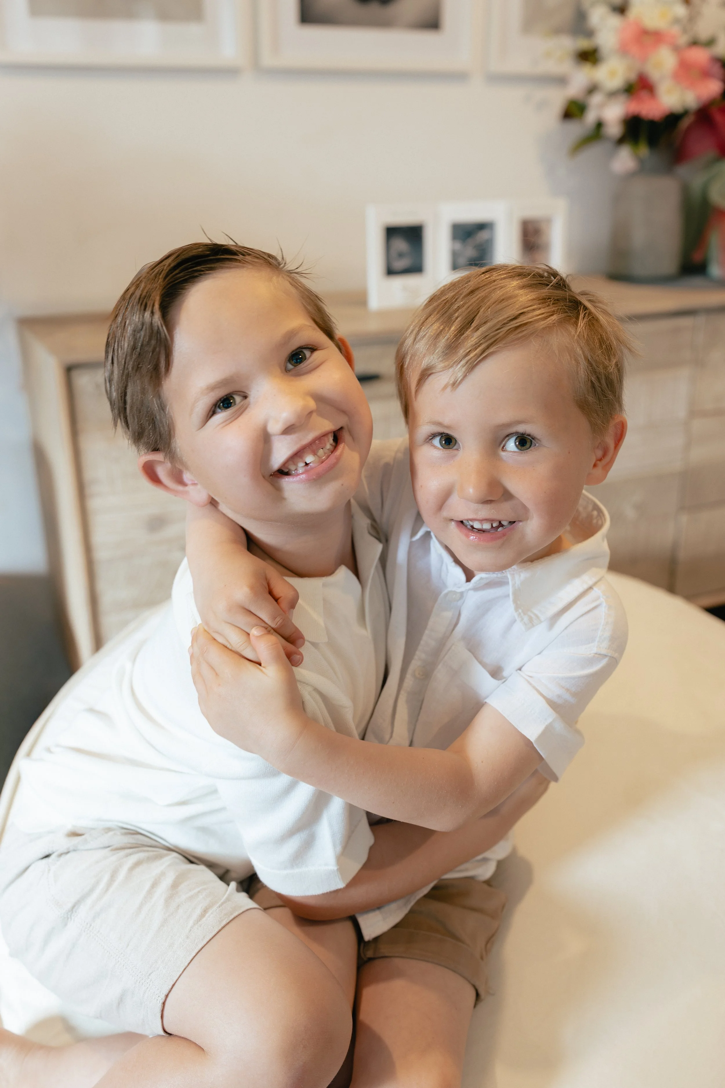 young brothers smiling at home during new born photo shoot