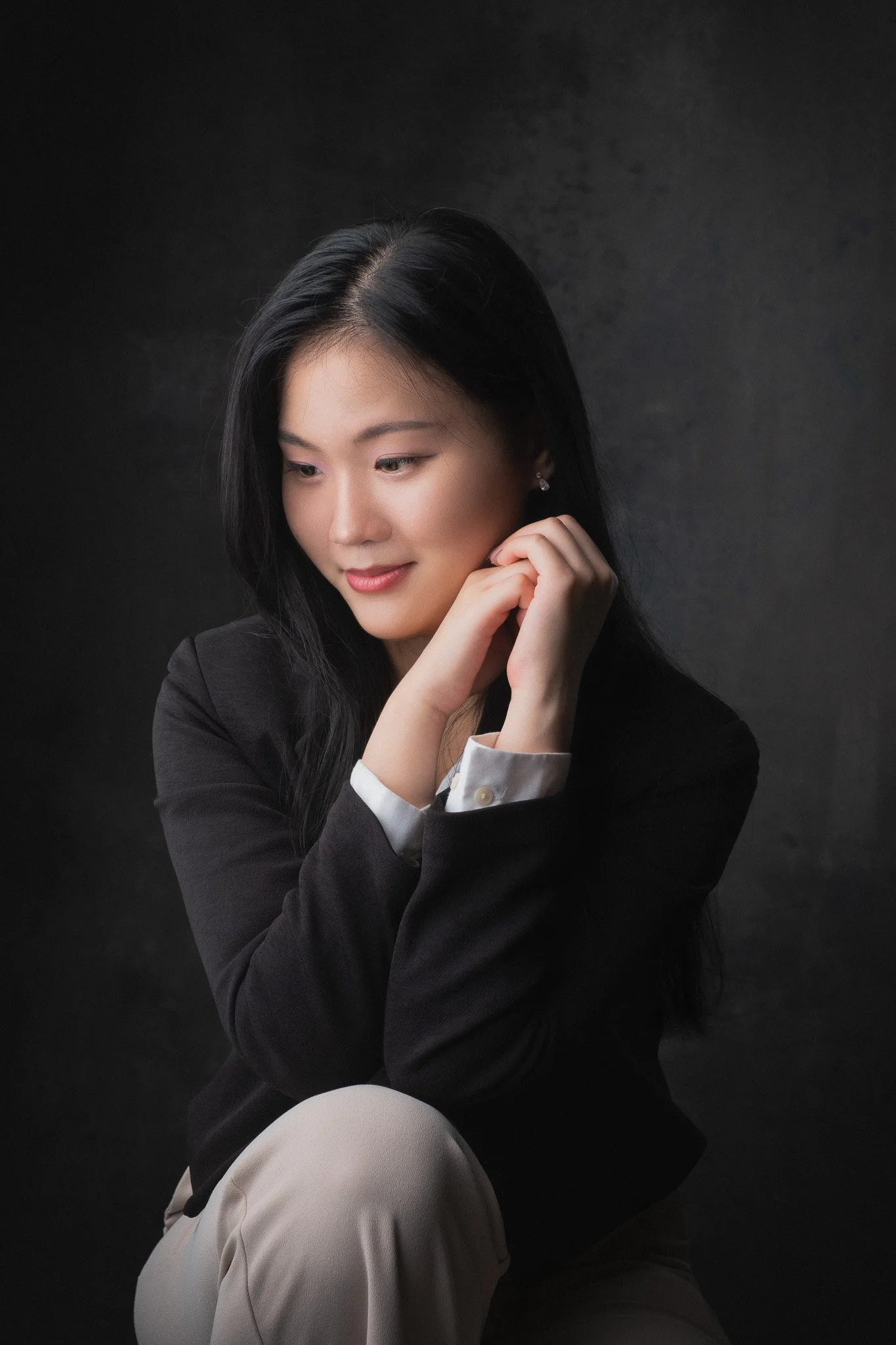 Expressive portrait of a young woman looking down with a slight smile. 