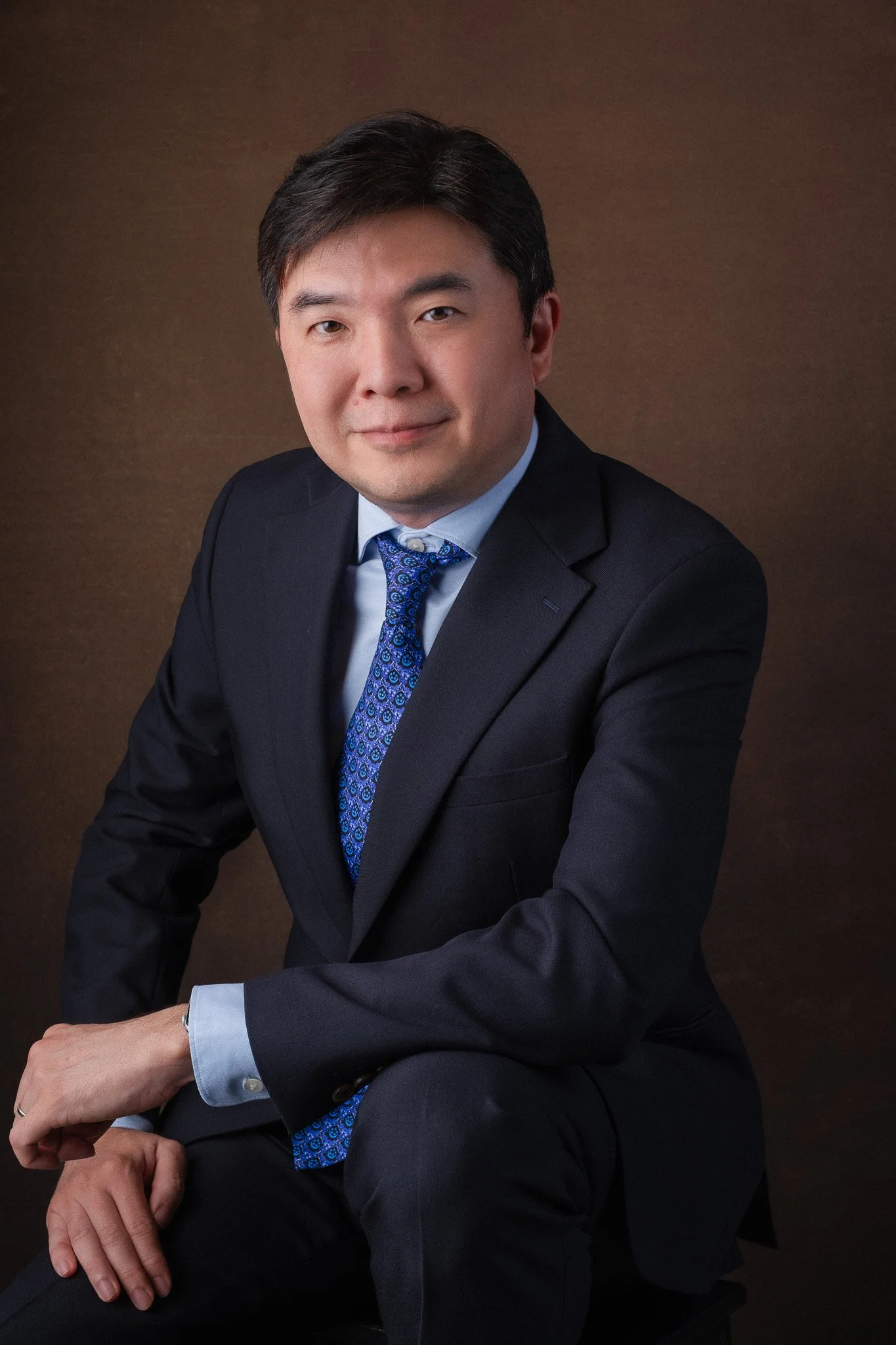 Executive portrait for Vincent Toh, principal of Assumption English School, Singapore. He is seated and smiling at the camera. 