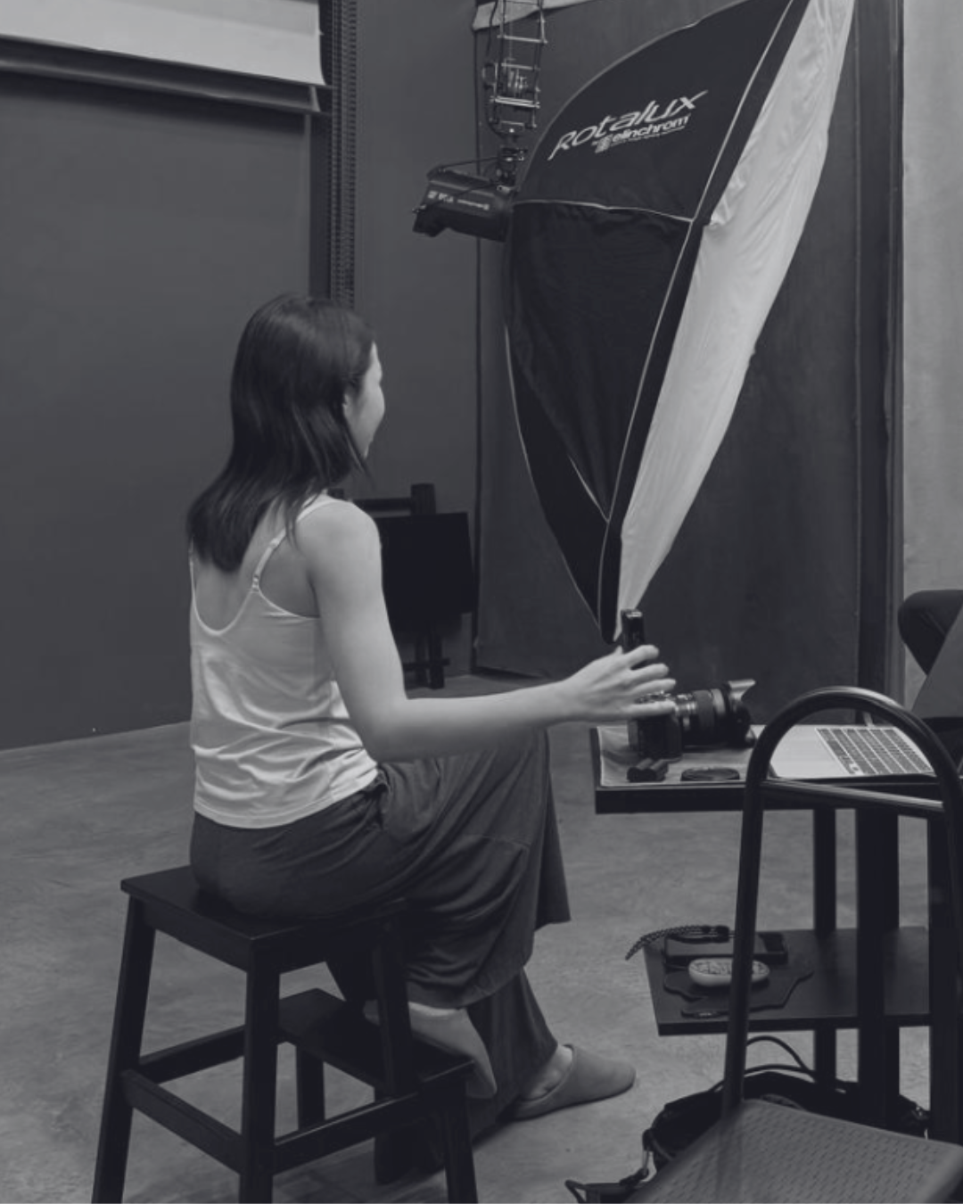 Behind the scenes of a portrait session, with photographer Shaan Ng engaging a client in the studio before taking the photograph.