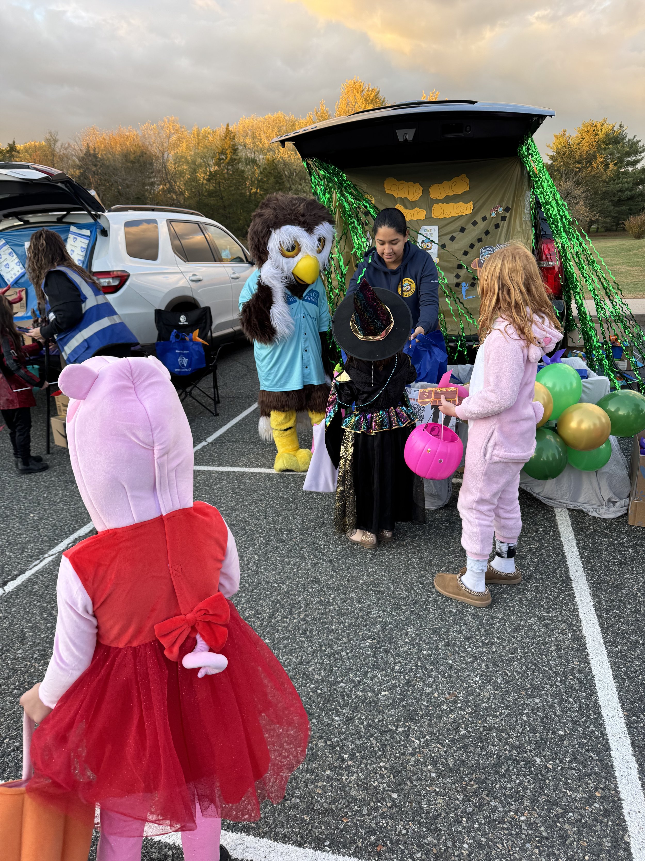 Amy giving kids bags with owlbert.jpeg