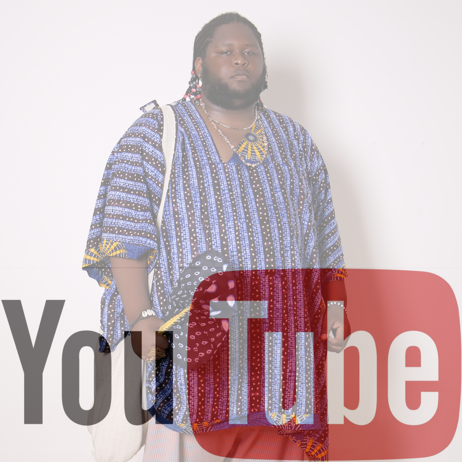 A person wearing a vibrant African patterned shirt and matching accessories, carrying a white shoulder bag, standing against a plain light-colored background.