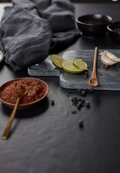 Pigalle porcelain benchtop styling scene, deep black resin-look surface with soft, velvety texture