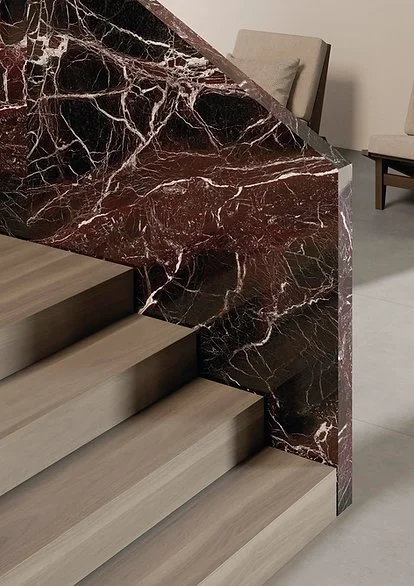 Stair cladding in Rosso Domus porcelain, polished red marble-look surface with bold veining