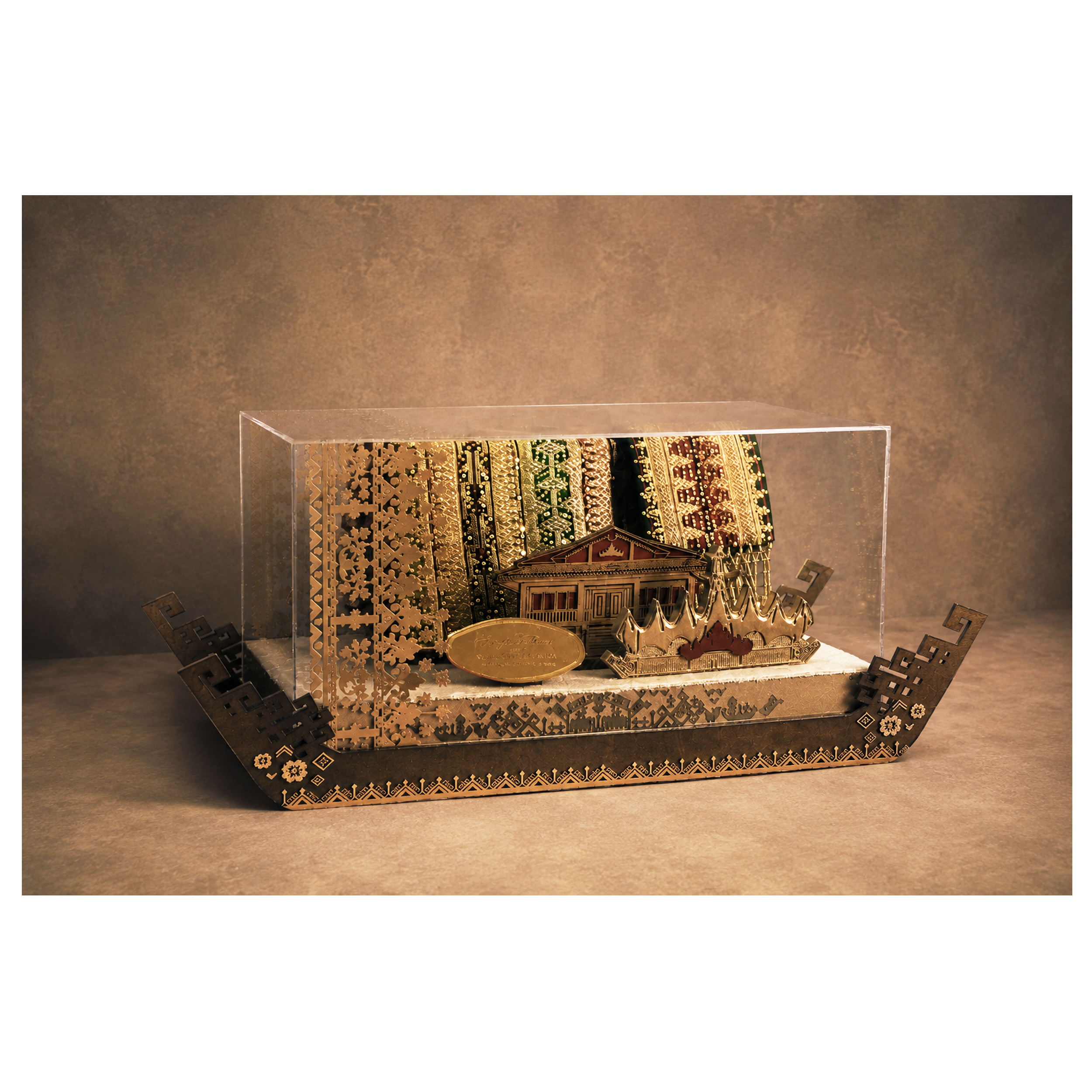 A display case with intricate gold and green patterned jewelry and decorative items inside, against a textured gold wall background.