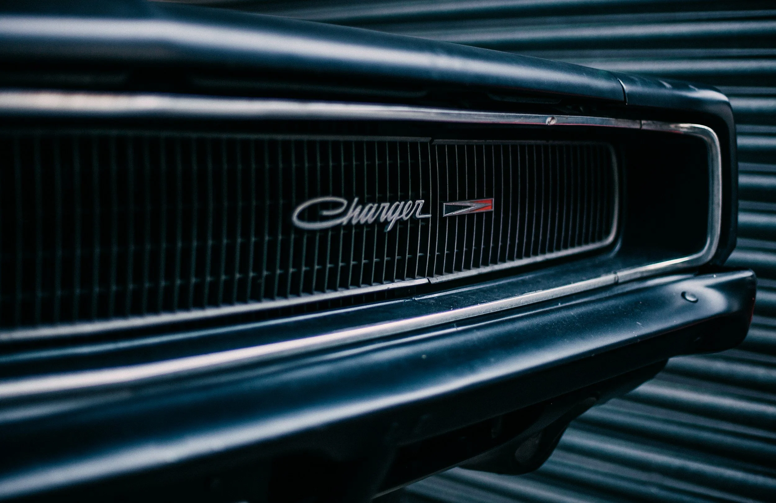 Close-up of the front grille and emblem of a classic Dodge Charger muscle car.