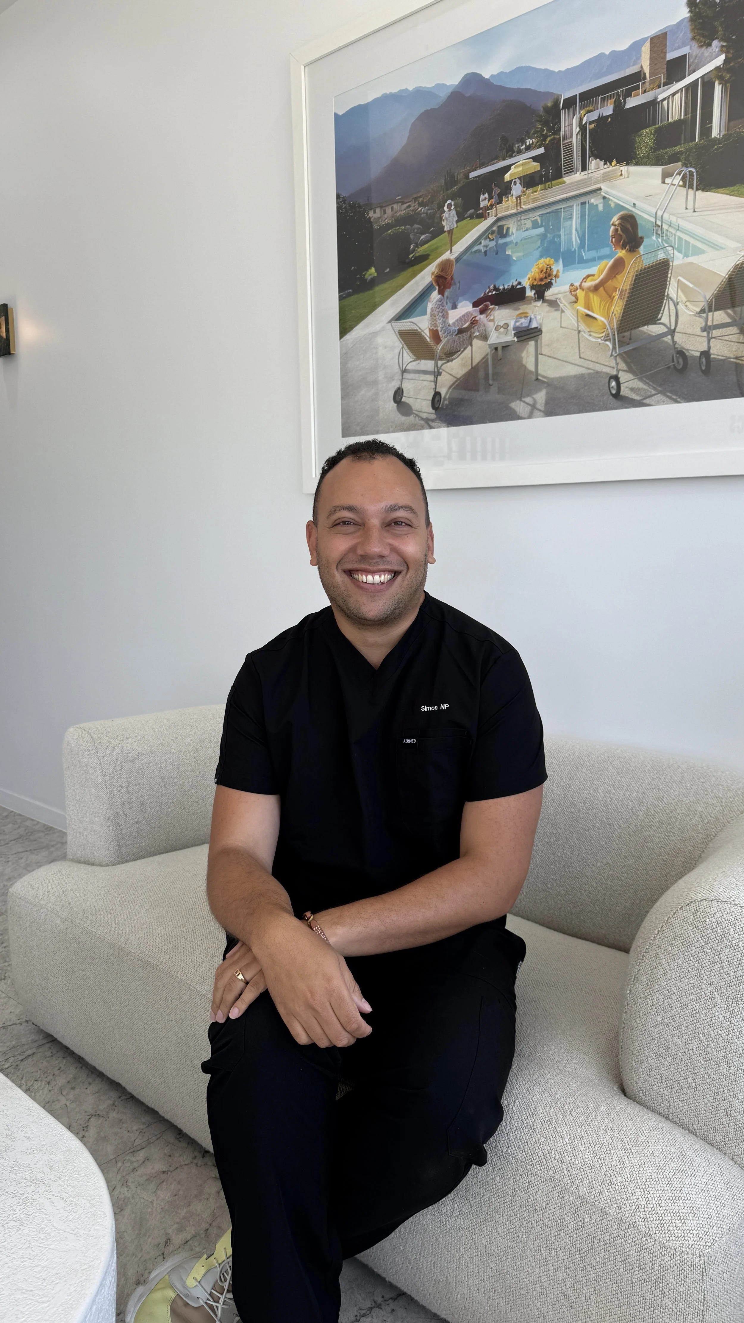 Simon Henning, nurse practitioner, seated in the Savu Studio clinic in Kingscliff, creating a welcoming space for aesthetic and wellness consultations.