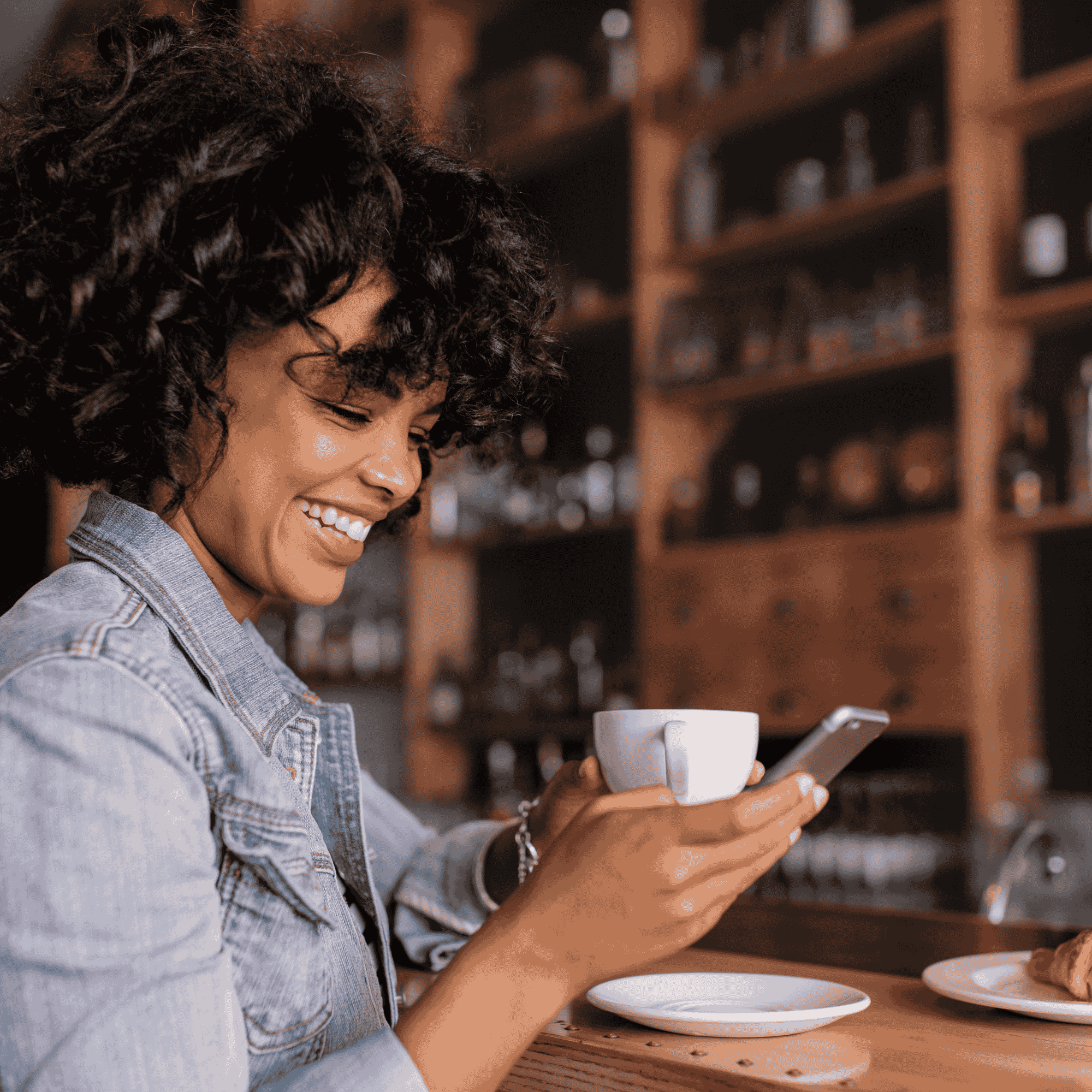 woman smiling whilst engaging with Bath Home Birth Gtoup whatsapp messages on her phone