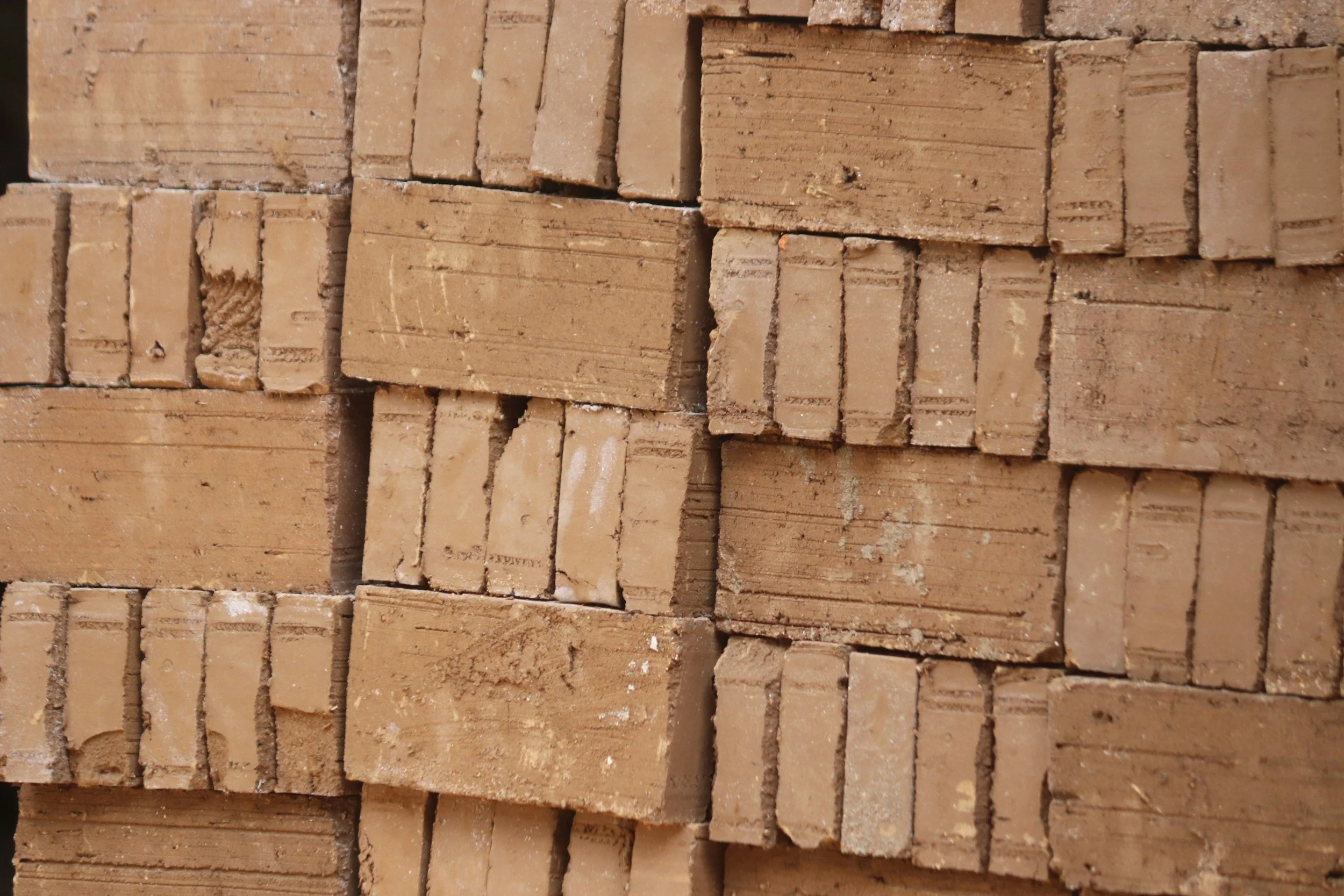 Stacked red bricks with rough texture and visible mortar lines.