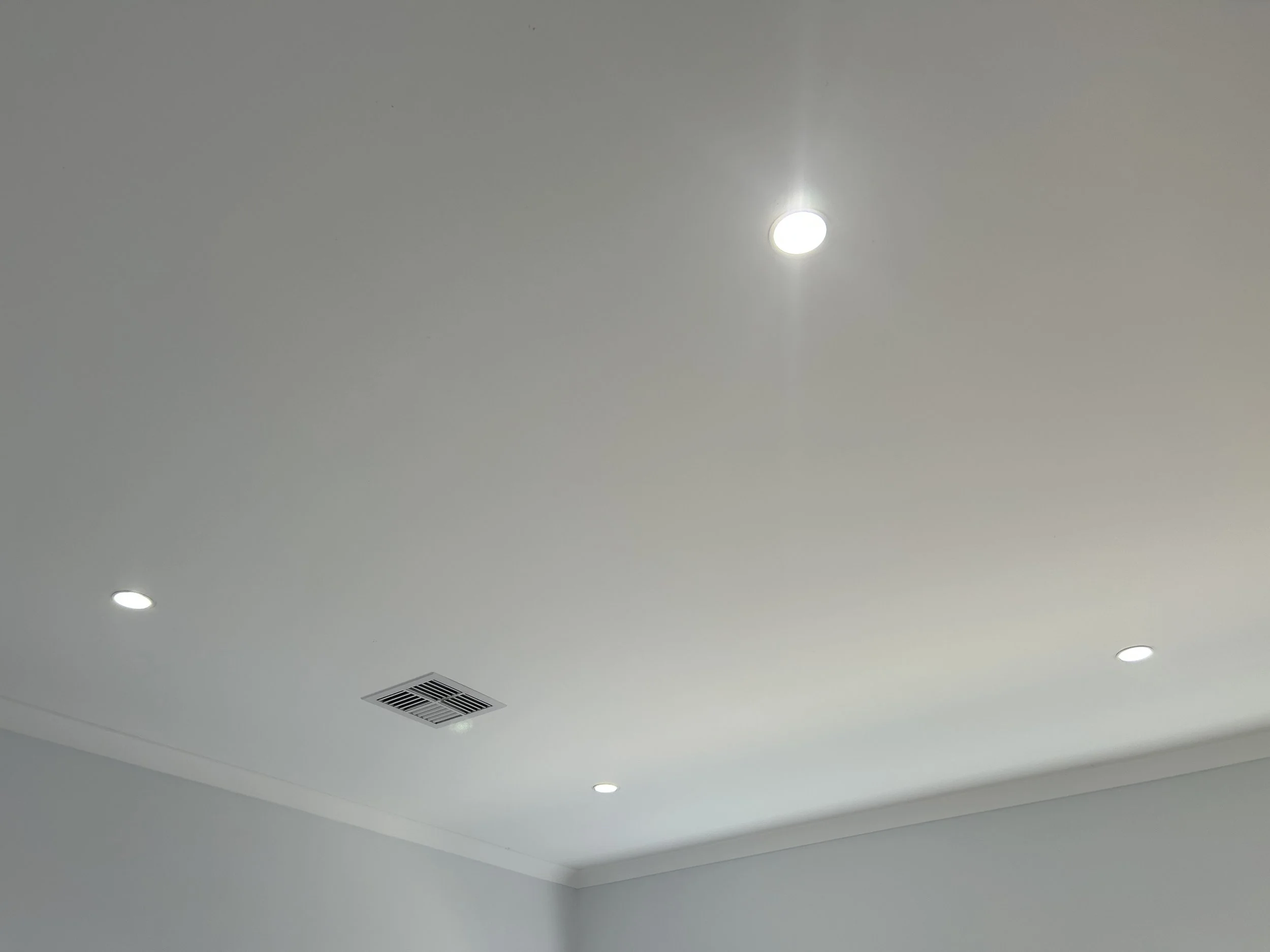 Ceiling with recessed lighting and an air vent.