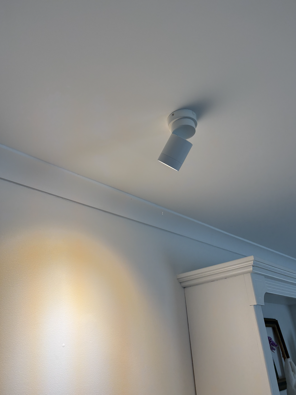 A white ceiling fan with a built-in light fixture, mounted on a white ceiling.