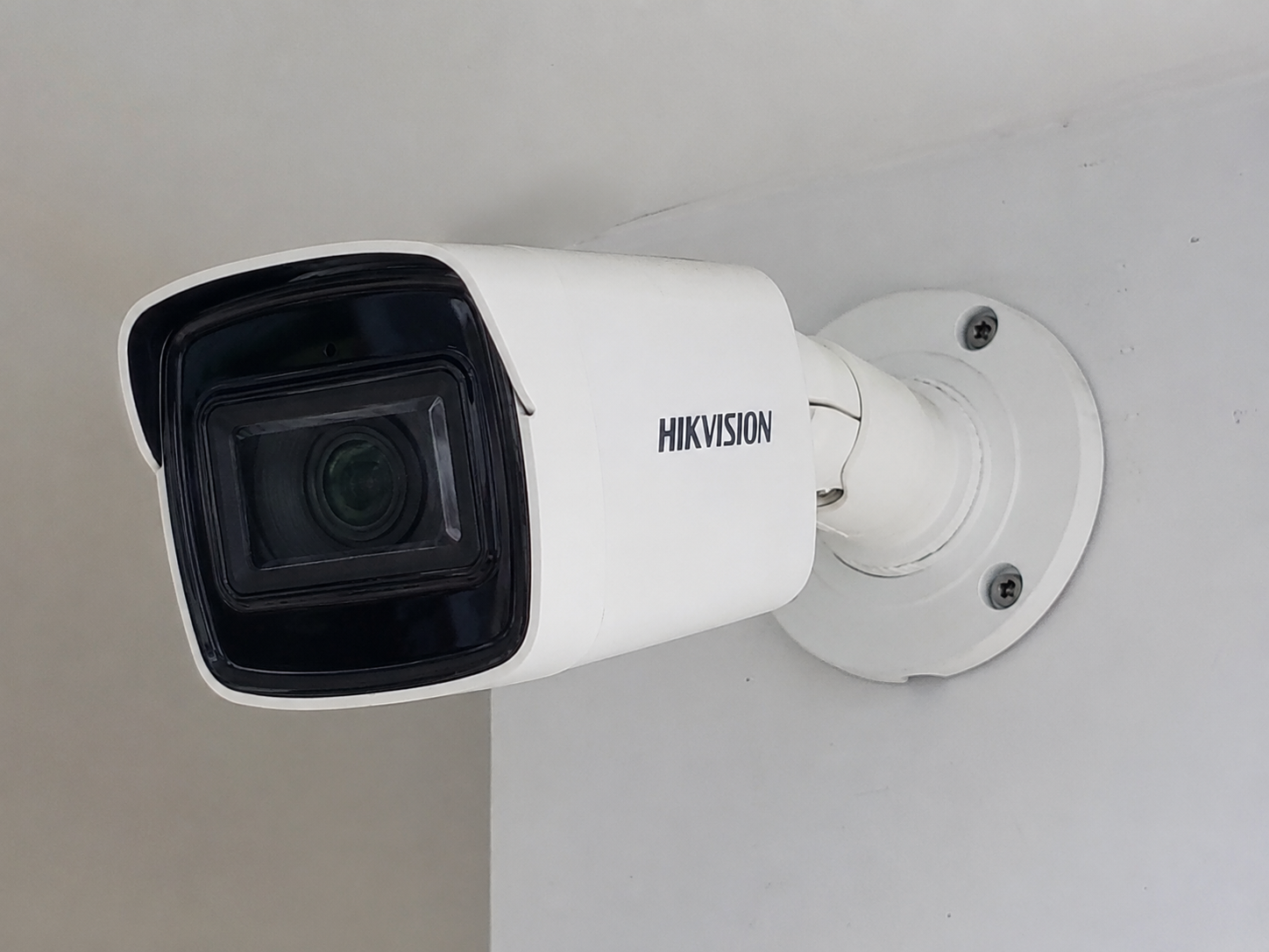 Security camera mounted on a white wall.