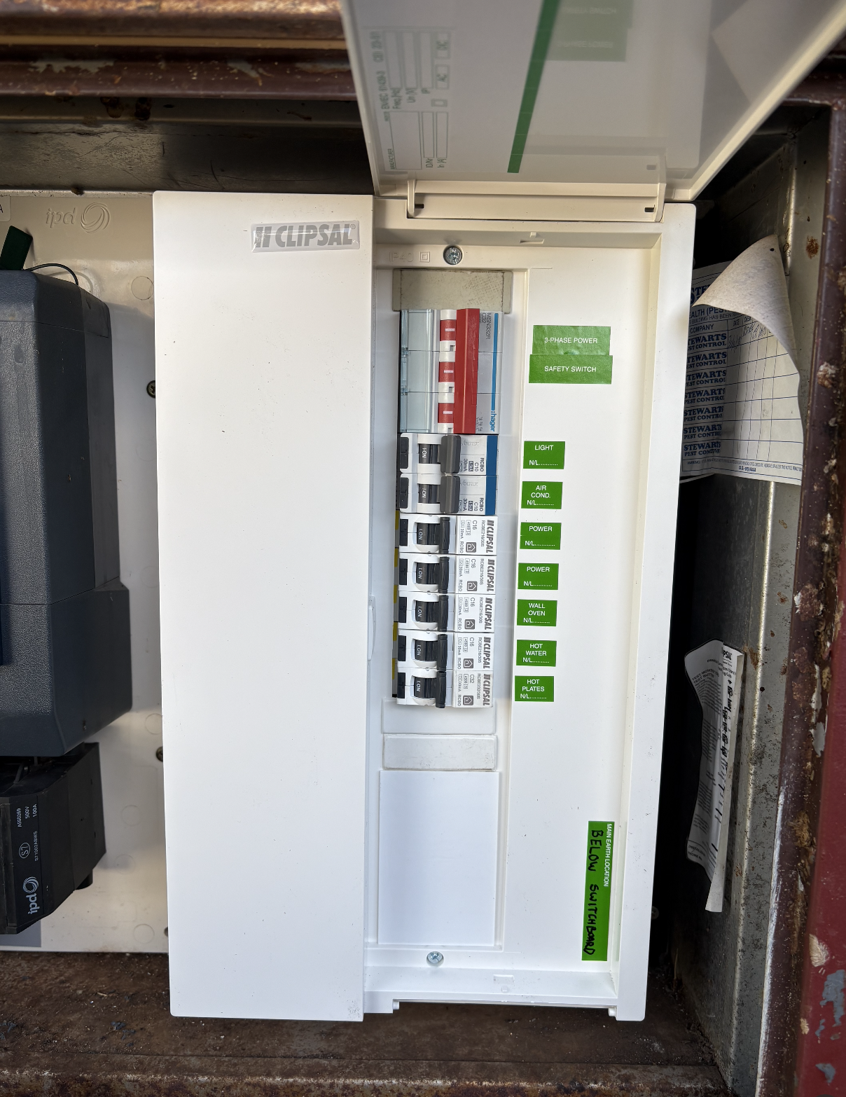 Electrical control panel with switches and labels for various functions, mounted inside a metal enclosure.