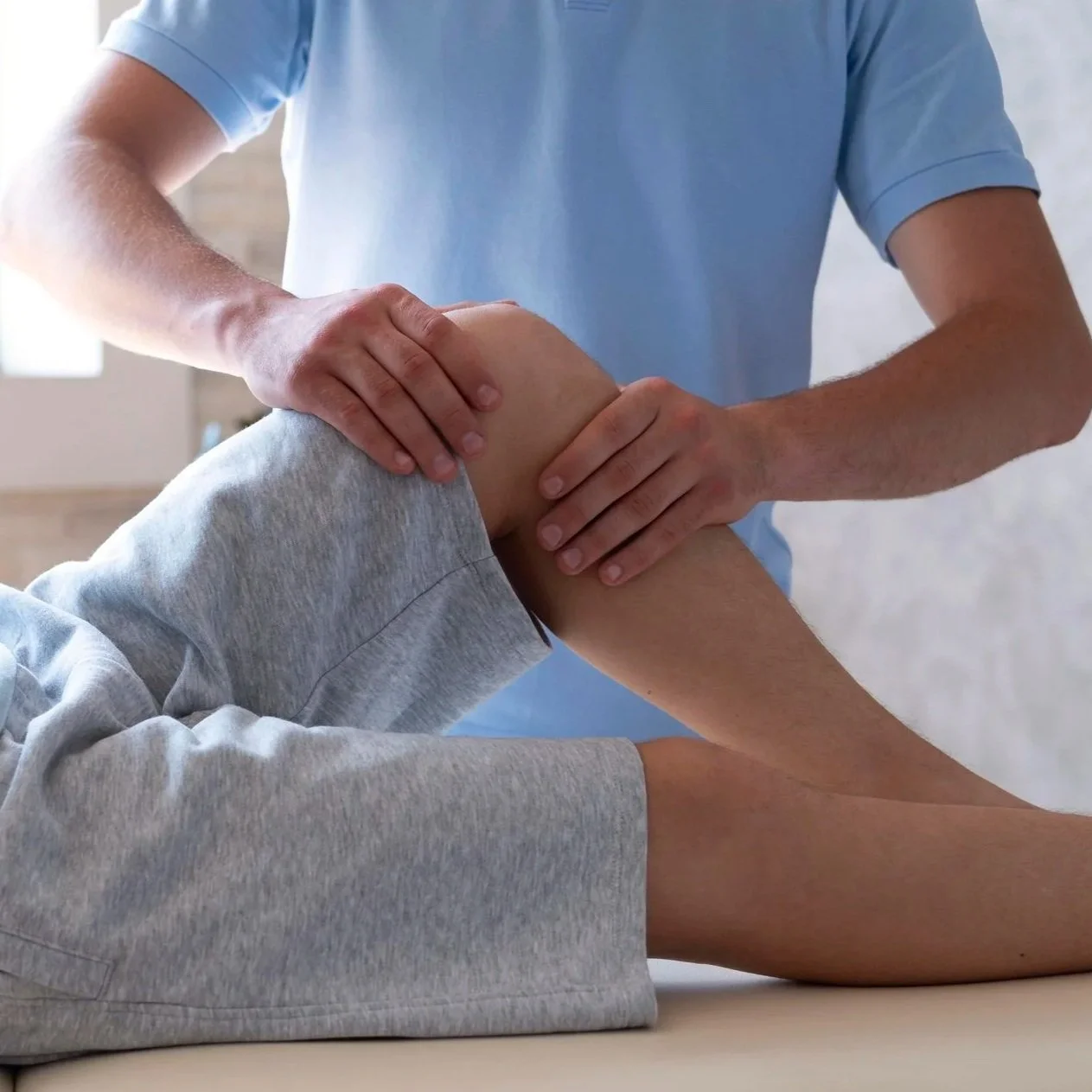 A person receiving a knee massage from a healthcare professional.