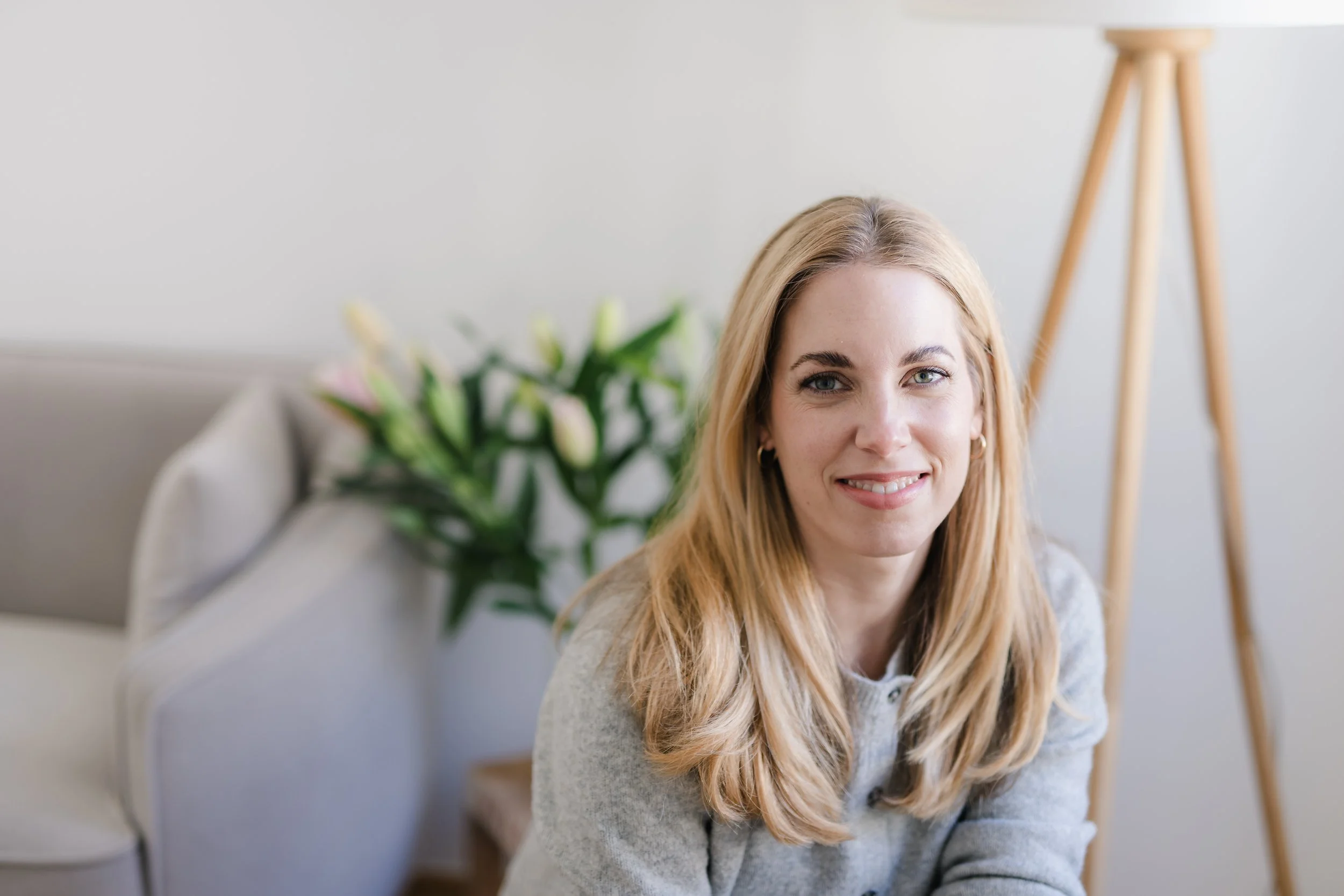 Katharina Plamberger, Mentaltrainerin für Frauen, lächelt in einem hellen Raum in die Kamera.
