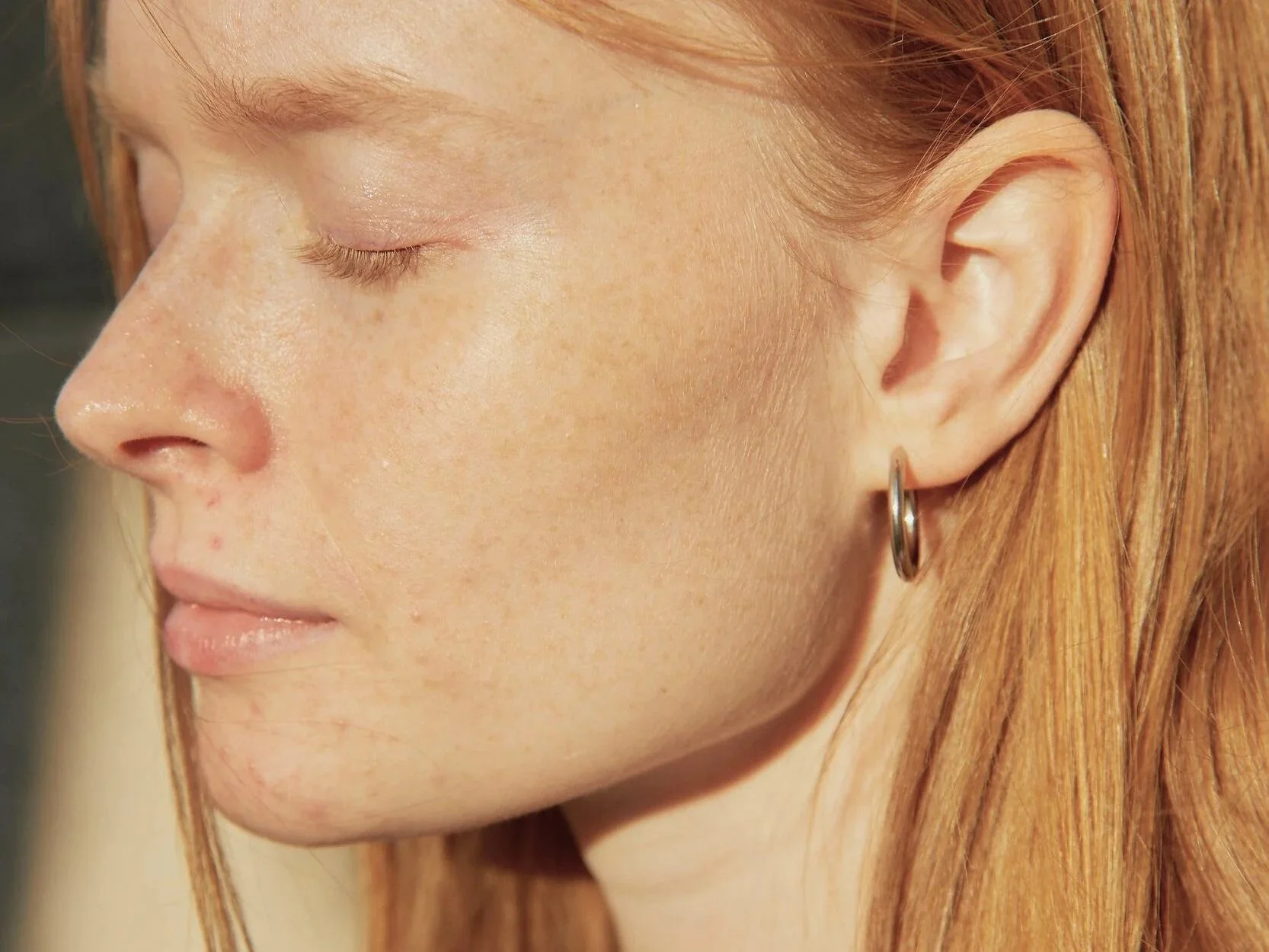 Eine Frau steht im Licht und schaut nachdenklich – symbolisch für Bewusstsein und Selbstfürsorge im Alltag.