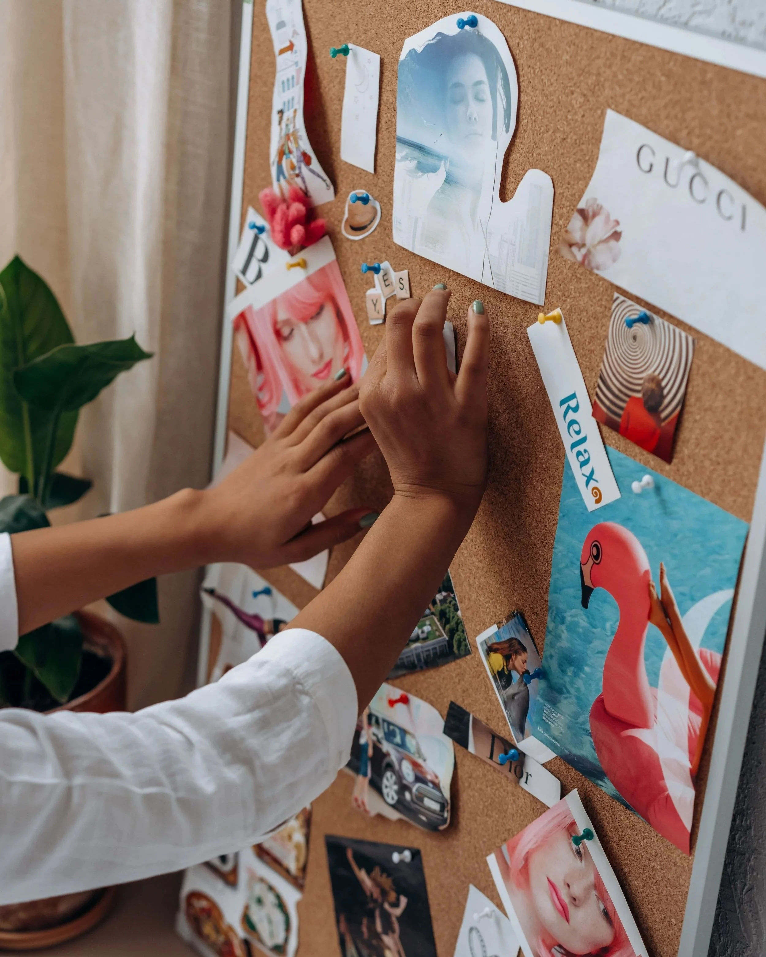 Frau gestaltet ein Visionboard mit Bildern