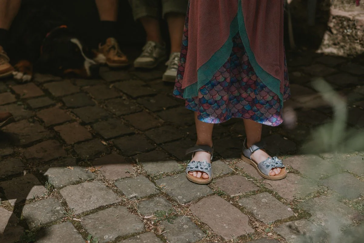 Detailaufnahme von Glitzer-Sandalen und Meerjungfrauen-Rock eines Schulkindes zur Einschulung in der Pfalz.
