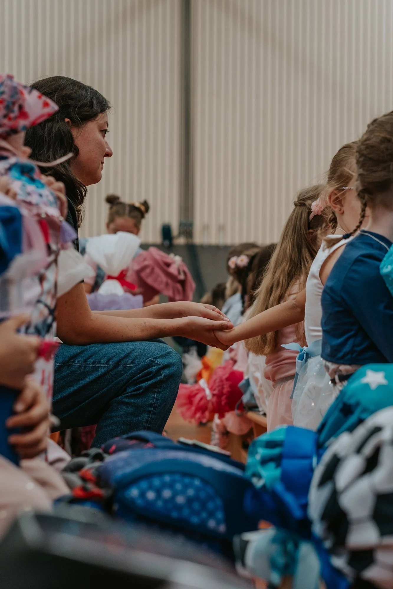 Eine Mama hält die Hand ihres Kindes während der Einschulung.