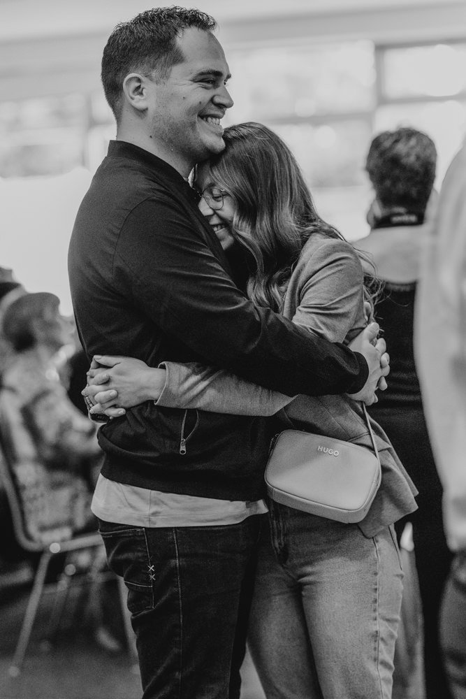 Mama und Papa umarmen sich während der Einschulung ihres Kindes.