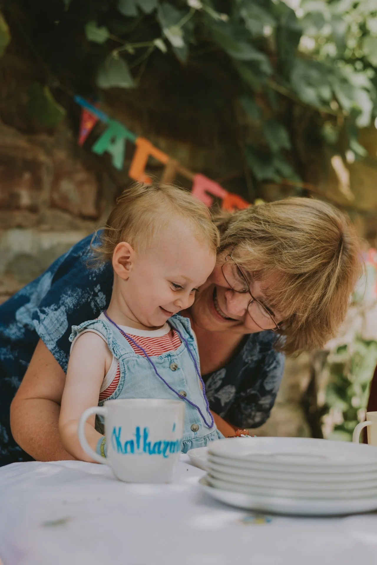 Herzlicher Moment: Oma umarmt Enkelkind von hinten zur Einschulung feiern in der Pfalz.