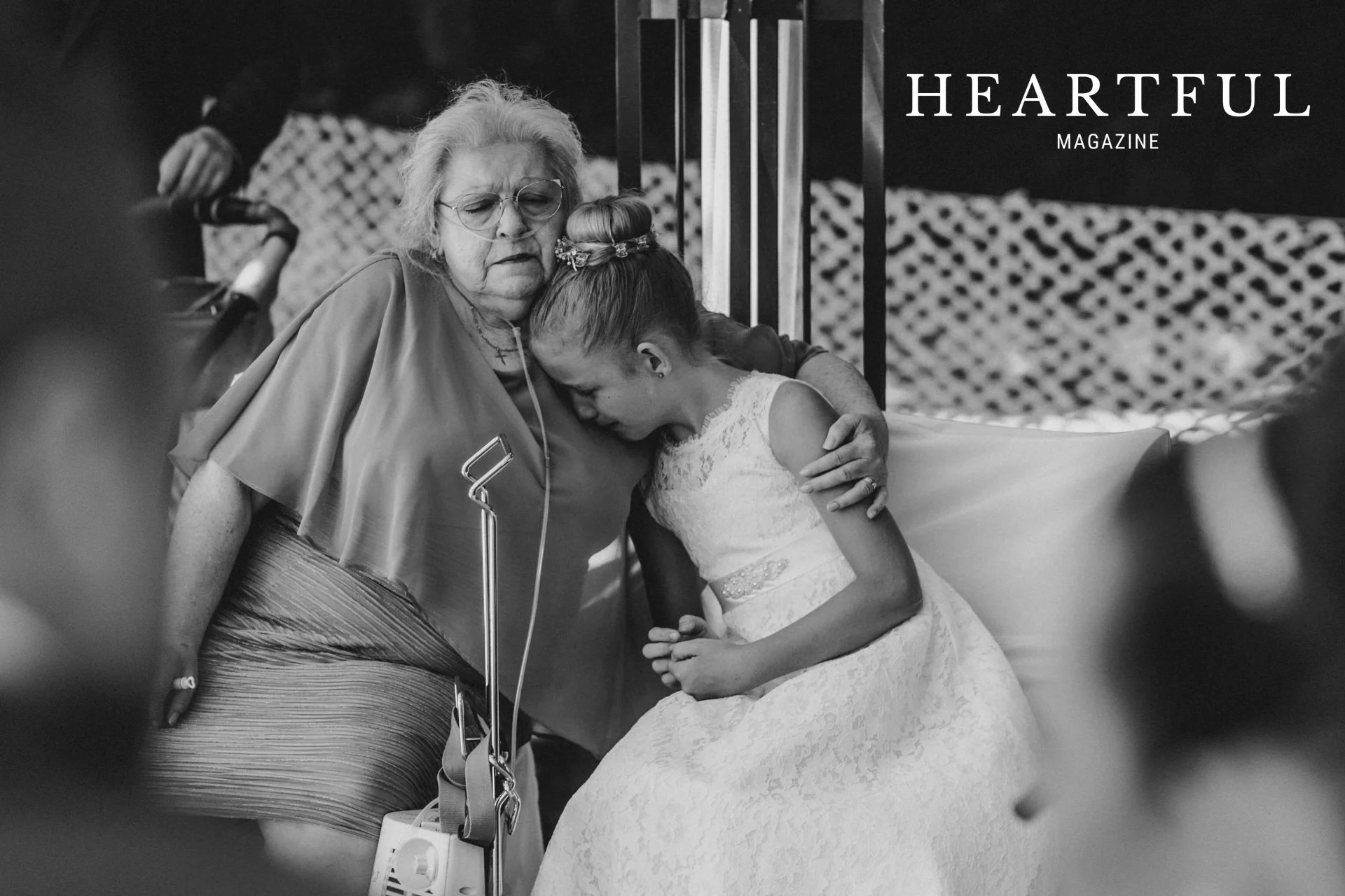 Großmutter mit Sauerstoffgerät tröstet ihre Enkelin während einer emotionalen Situation auf einer Hochzeit.