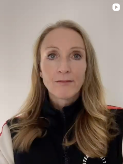 Paula Radcliffe - A woman with long blonde hair and blue eyes looking directly at the camera, wearing a black jacket with red and white accents against a plain background.