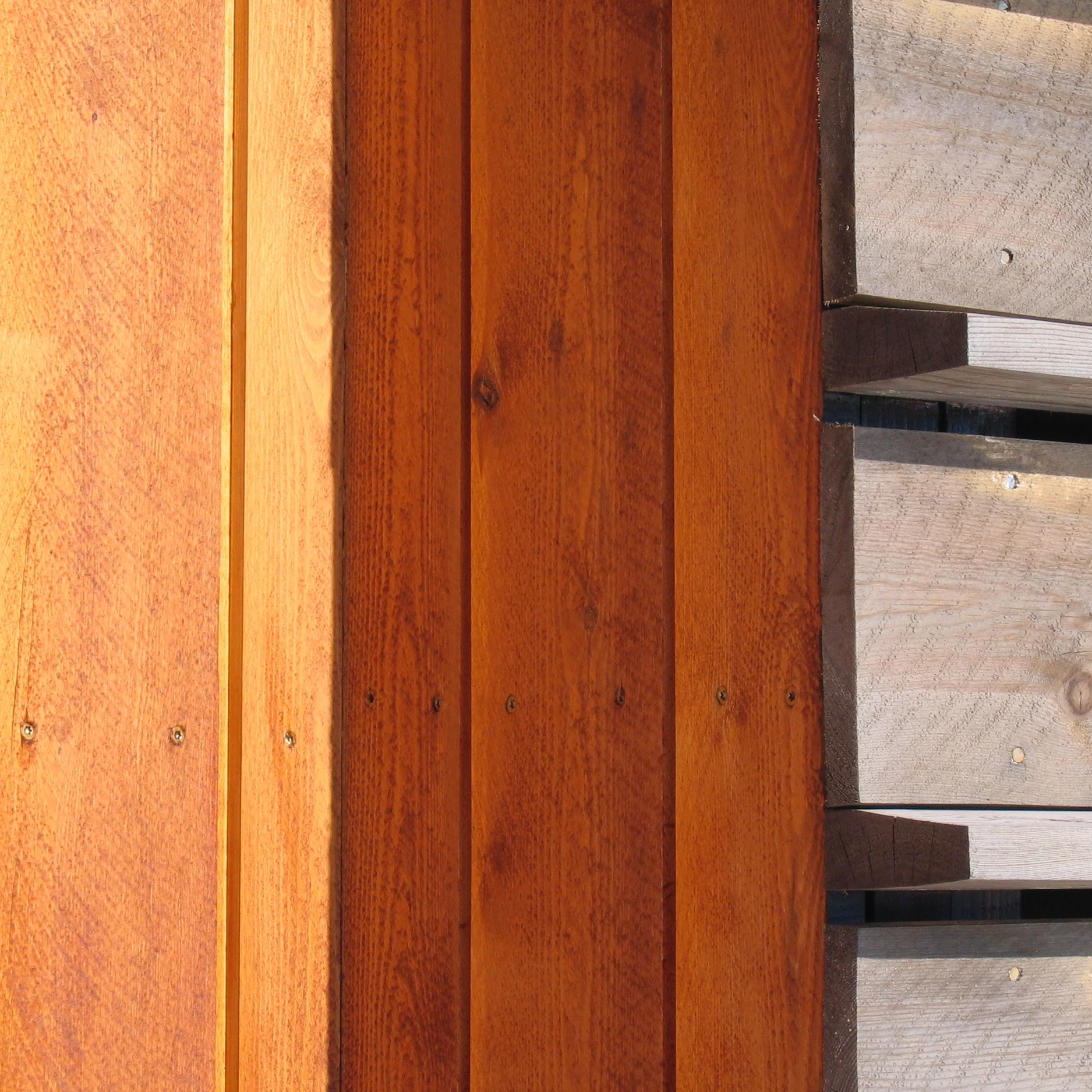 Close-up of wooden planks with varied colors and textures, arranged side by side.