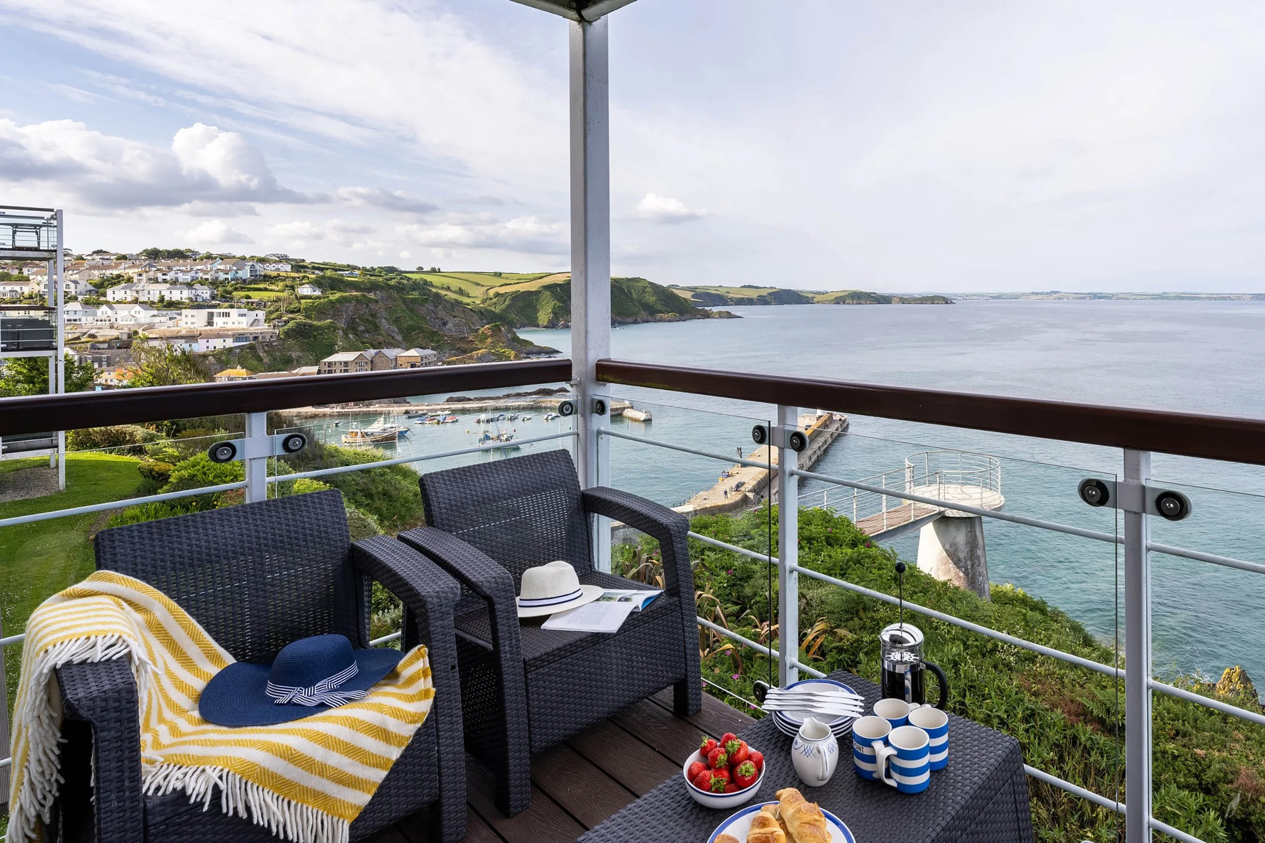 Day time view from the balcony of the Marine Point apartment. Chairs and low table in foreground with afternoon tea set on it. 