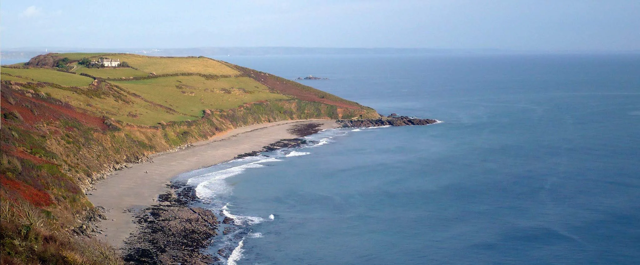 View overlooking Vault Beach, a large sandy bow-shaped beach near Gorran Haven in Cornwall