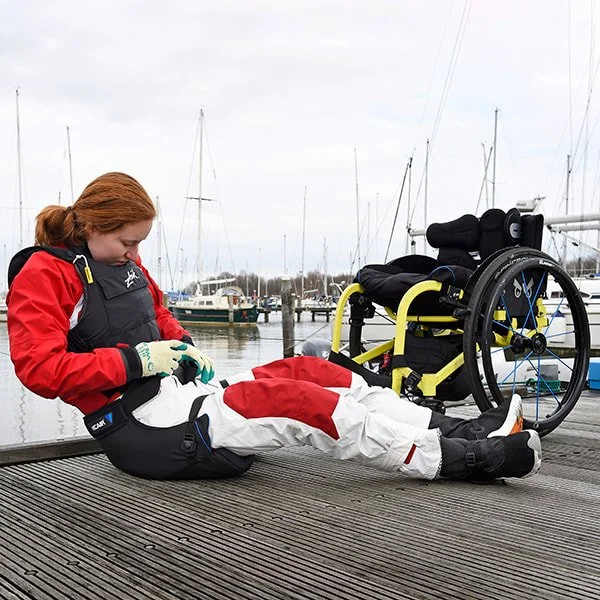 woman on a jetty adjusting her Vicair before sailing