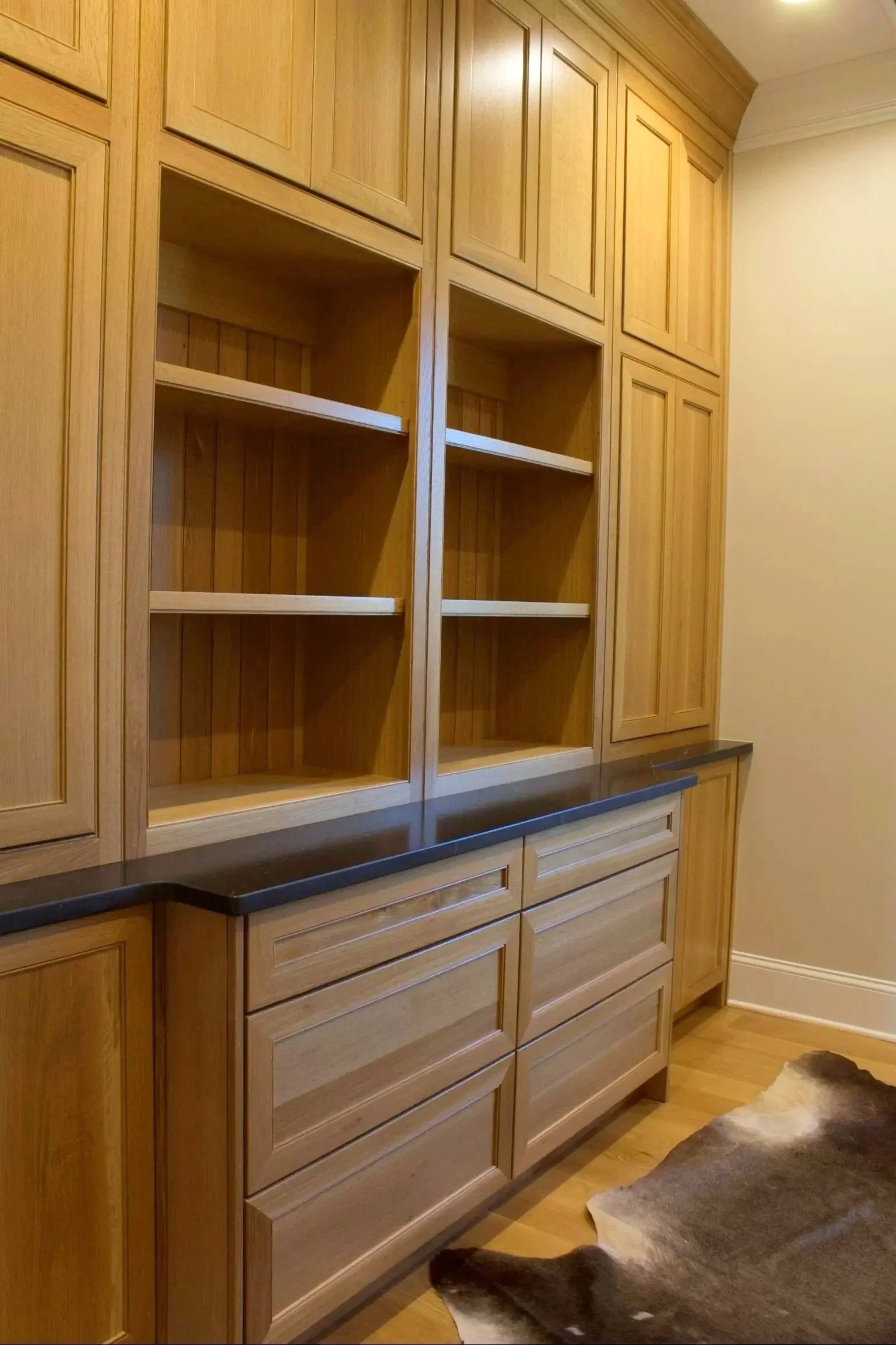 Custom White oak home office with bookshelves, natural finish, and black stone counter top by Crawford Cabinets