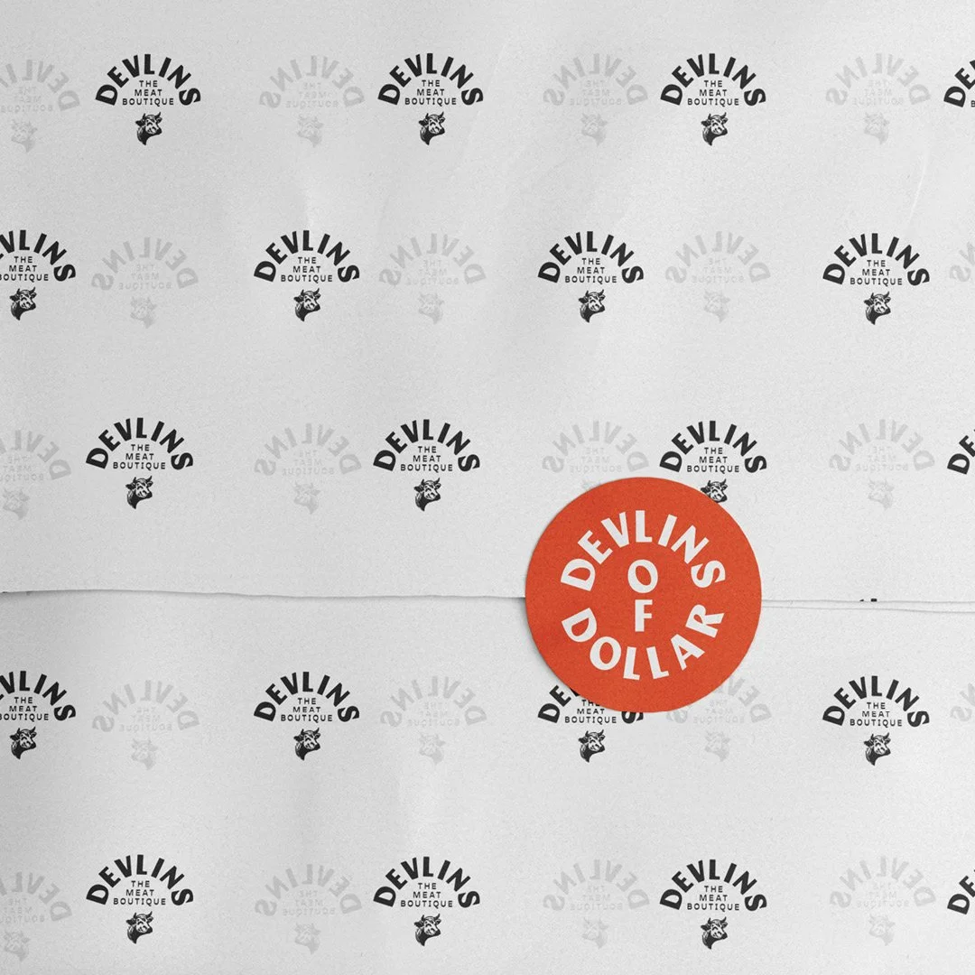 A white package from Devilins The Meat Boutique with a red circular sticker that says 'Devilins of DOLLARS'.