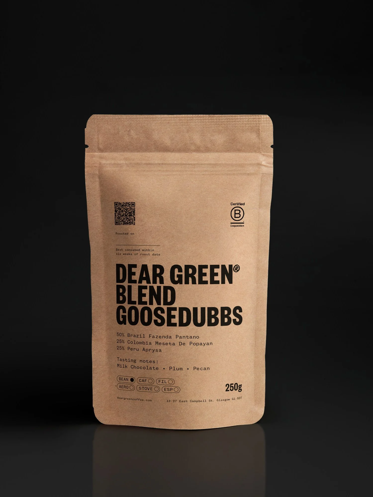 A brown coffee bag with black text labeled Dear Green Blend Goosedubs, with mix of coffee beans and tasting notes of milk chocolate, plum, and pecan.
